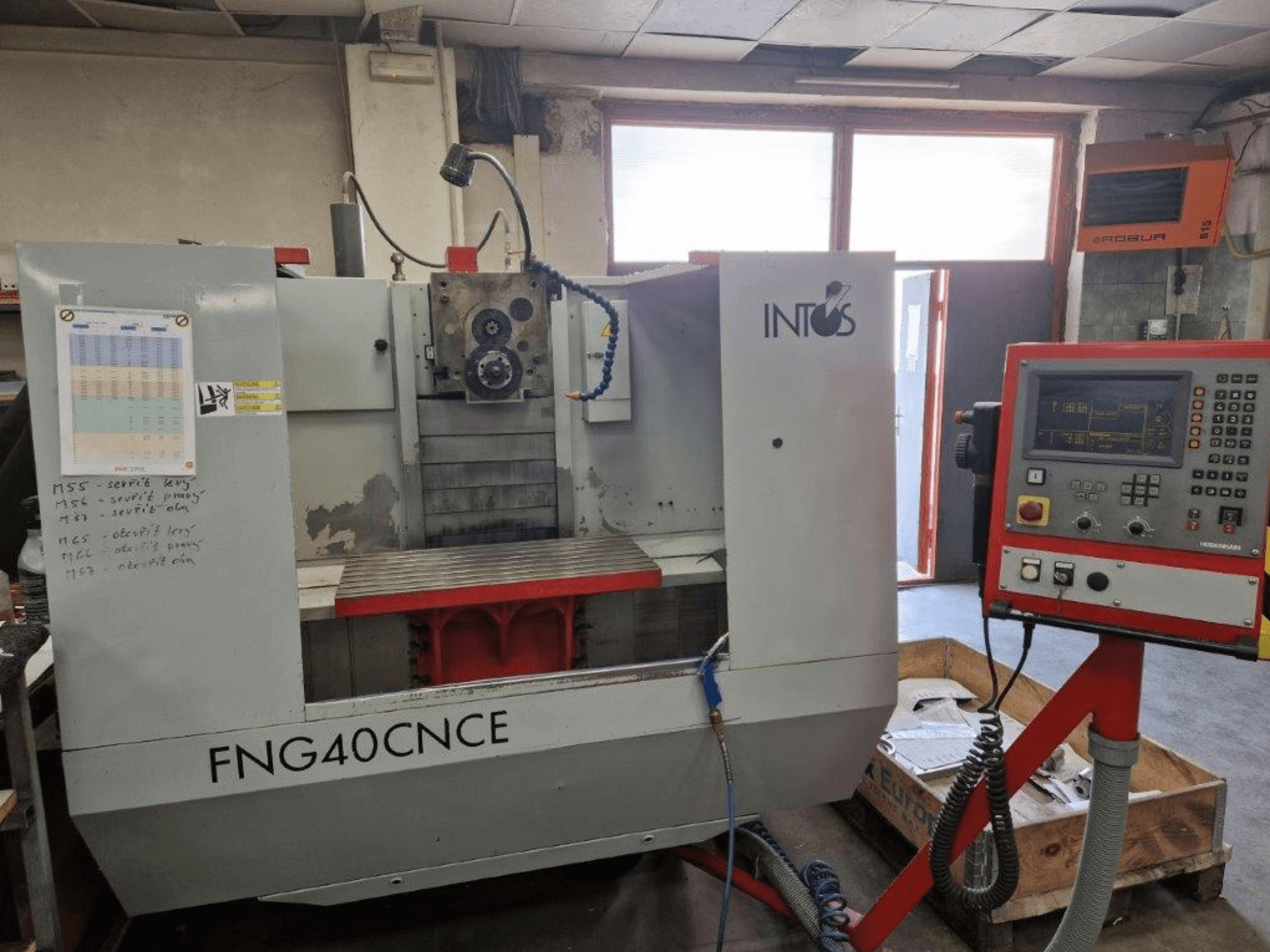 Macchina INTOS FNG40CNC, vista frontale, con pannello di controllo, parti operative e piano di lavoro in metallo. Ideale per la lavorazione.