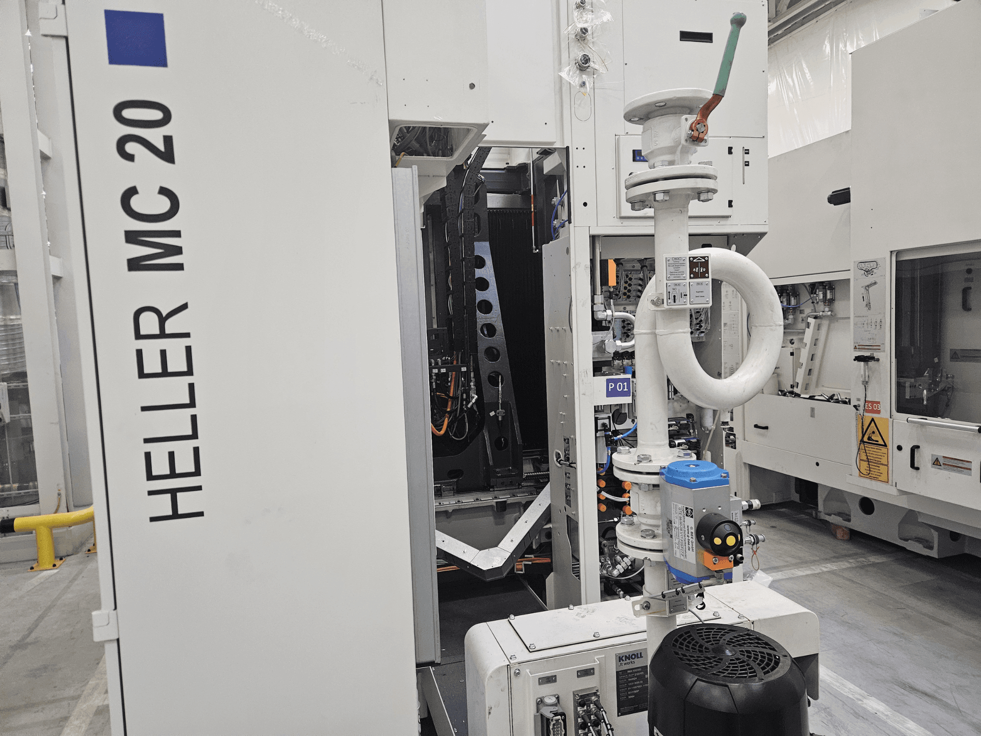 Macchina Heller MC 20 in un ambiente di fabbrica, che mostra il pannello di controllo e i componenti meccanici da una vista laterale.