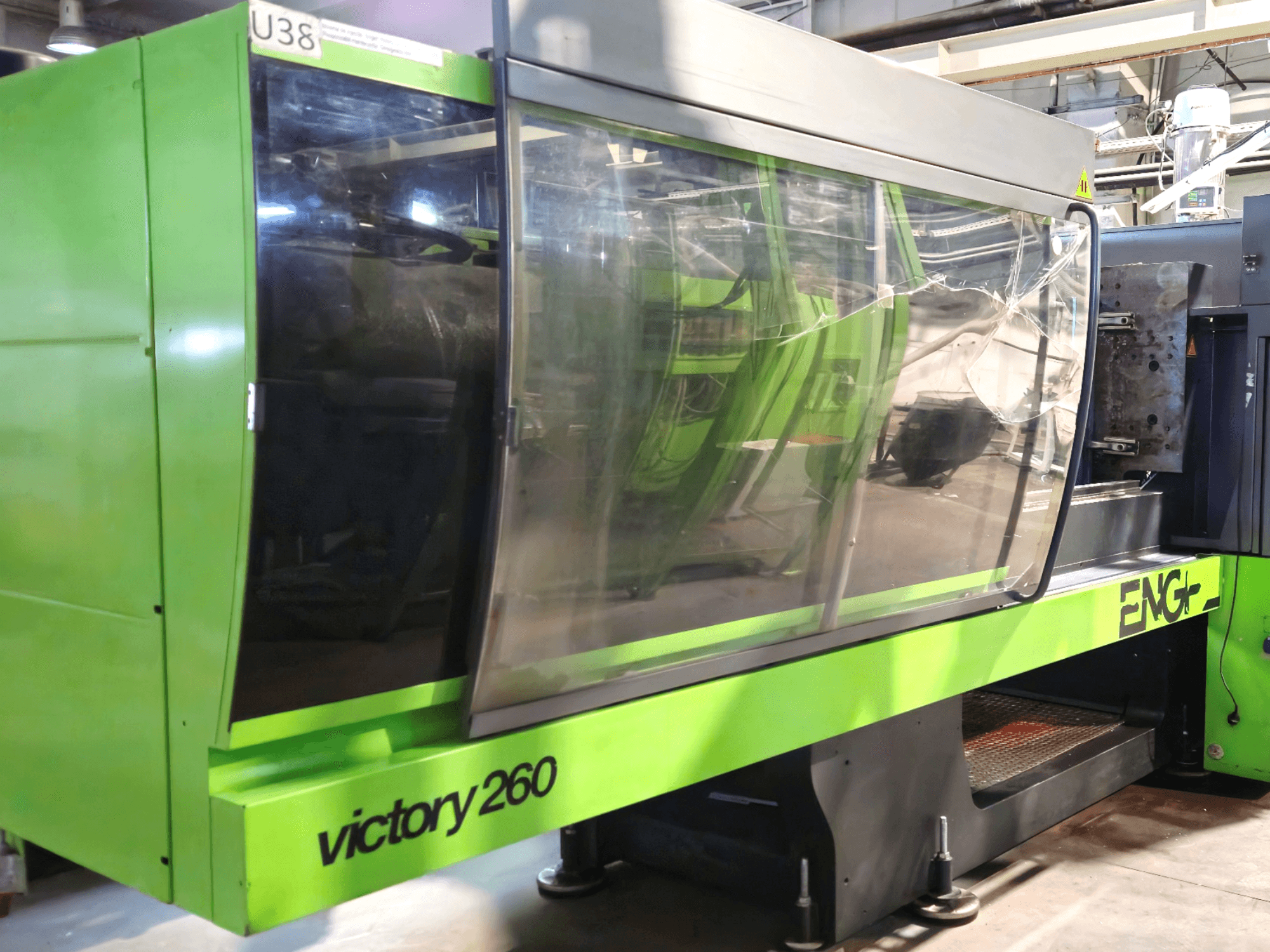 Macchina per stampaggio a iniezione ENG victory 260, vista frontale; presenta un esterno verde e un ampio pannello di vetro per la visibilità.