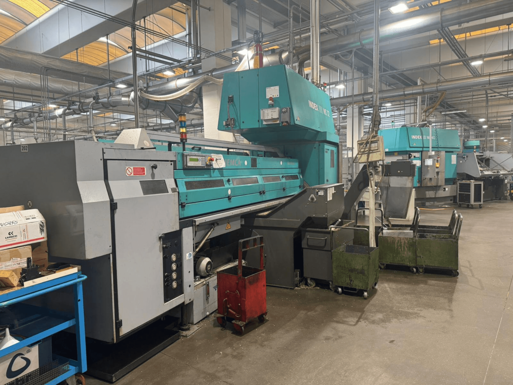 Tornio multimandrino INDEX MS32C, vista frontale che mostra i comandi e l'area operativa in un'officina.