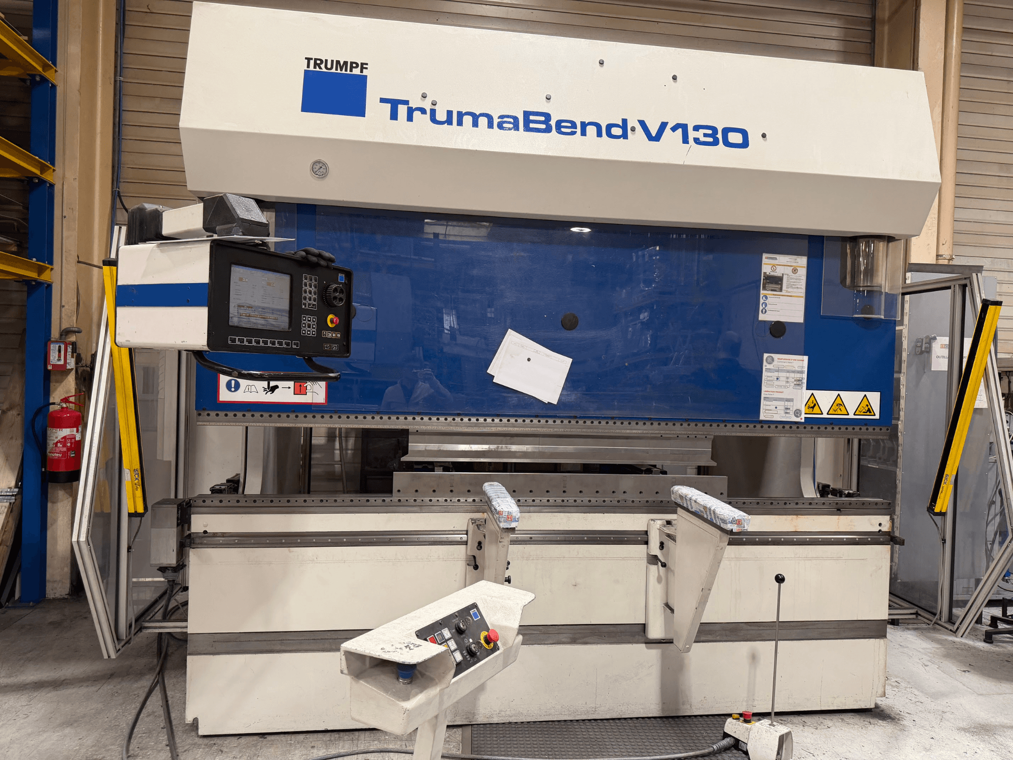 Piegatrice TRUMPF TrumaBend V130 in ambiente industriale, dotata di pannello di controllo e dispositivi di sicurezza, vista frontale.