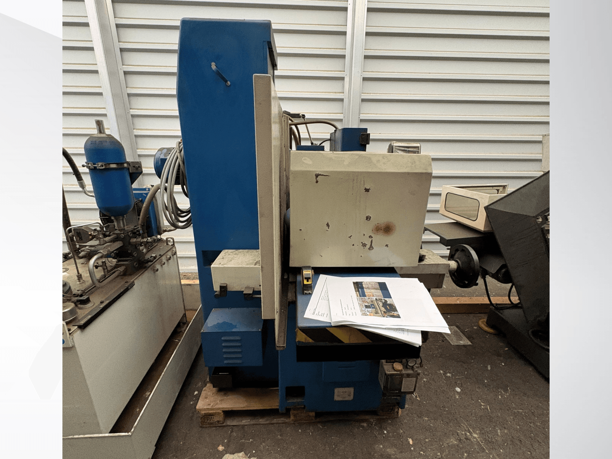 Rettificatrice piana KNUTH, modello HFS 30638 C, vista di profilo con il pannello di comando e alcuni documenti cartacei sul tavolo.