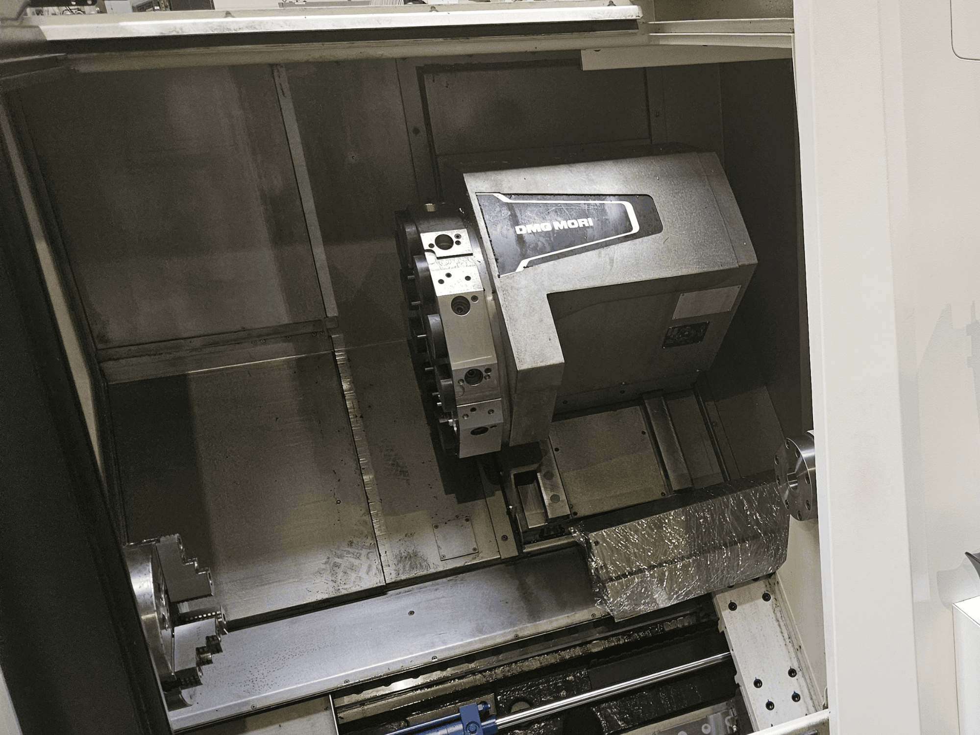 Vista interna del tornio orizzontale DMG MORI CLX 450 V4, che mostra il mandrino e l'interfaccia di controllo.