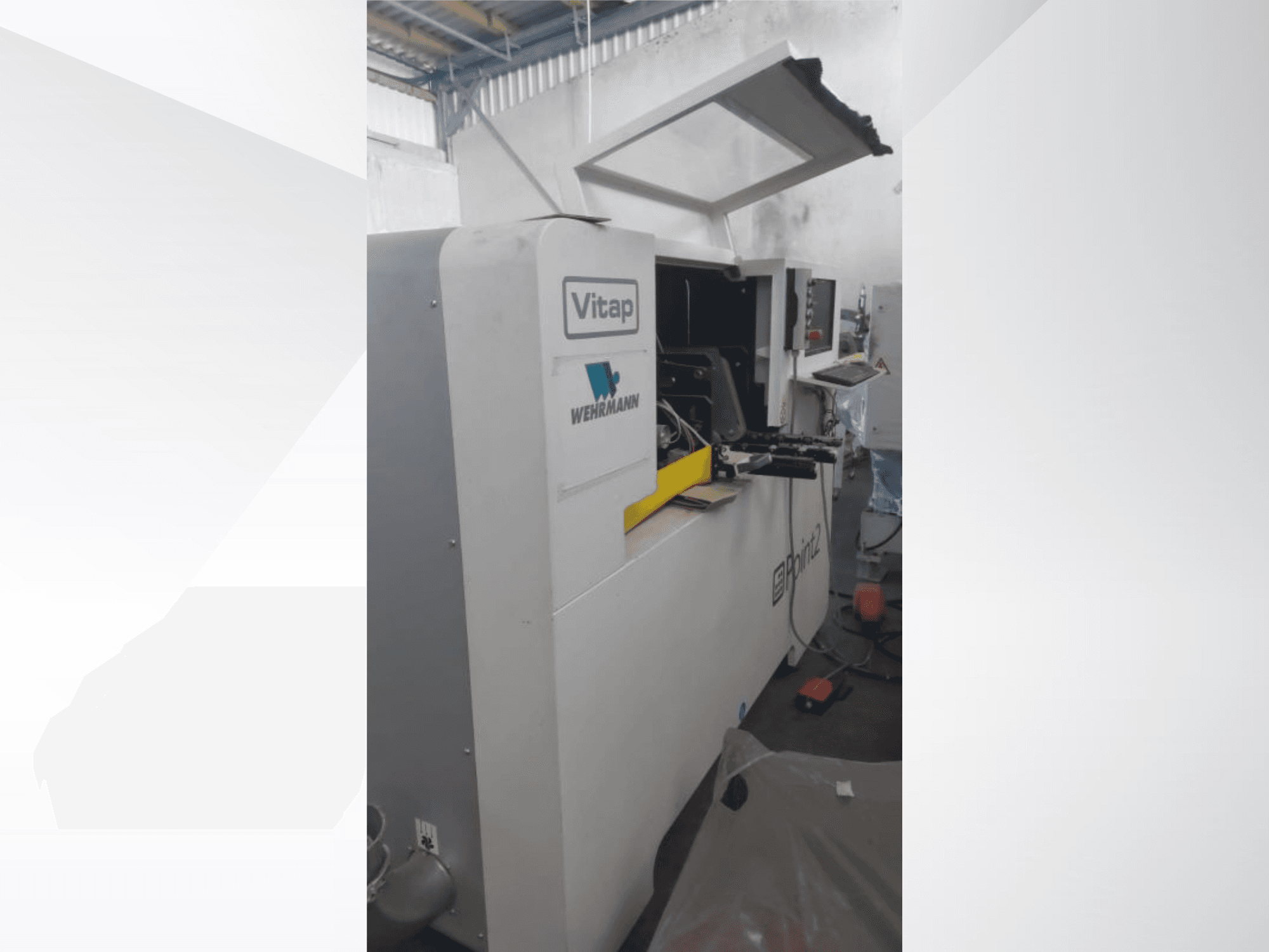 Centro di lavorazione CNC VITAP POINT 2 visto di profilo, con pannello di comando e coperchio aperto per facilitare l'accesso.