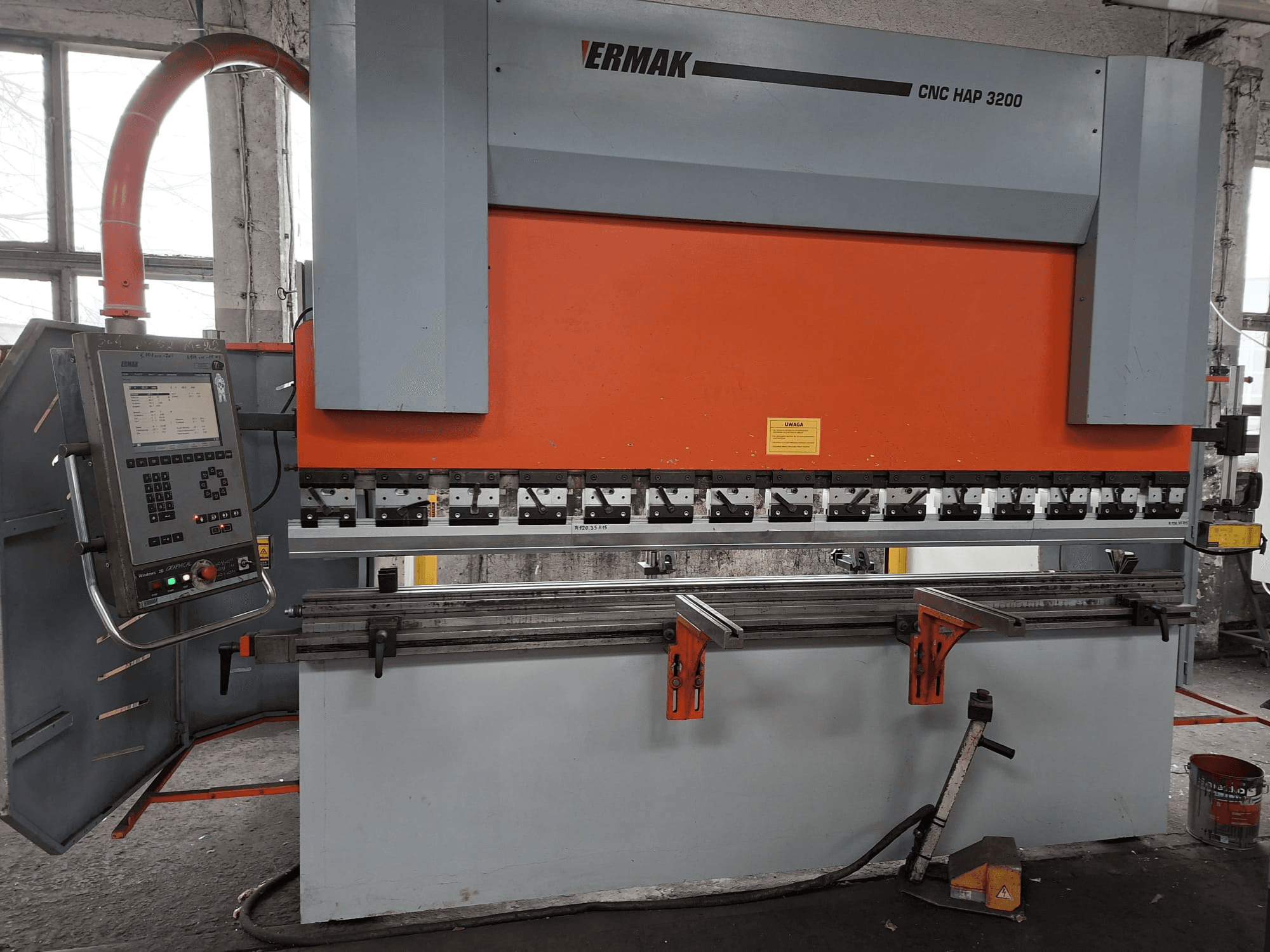 Pressa piegatrice Ermak CNC HAP 3200, vista frontale, con corpo arancione e grigio, pannello di controllo con display digitale e pinze regolabili.