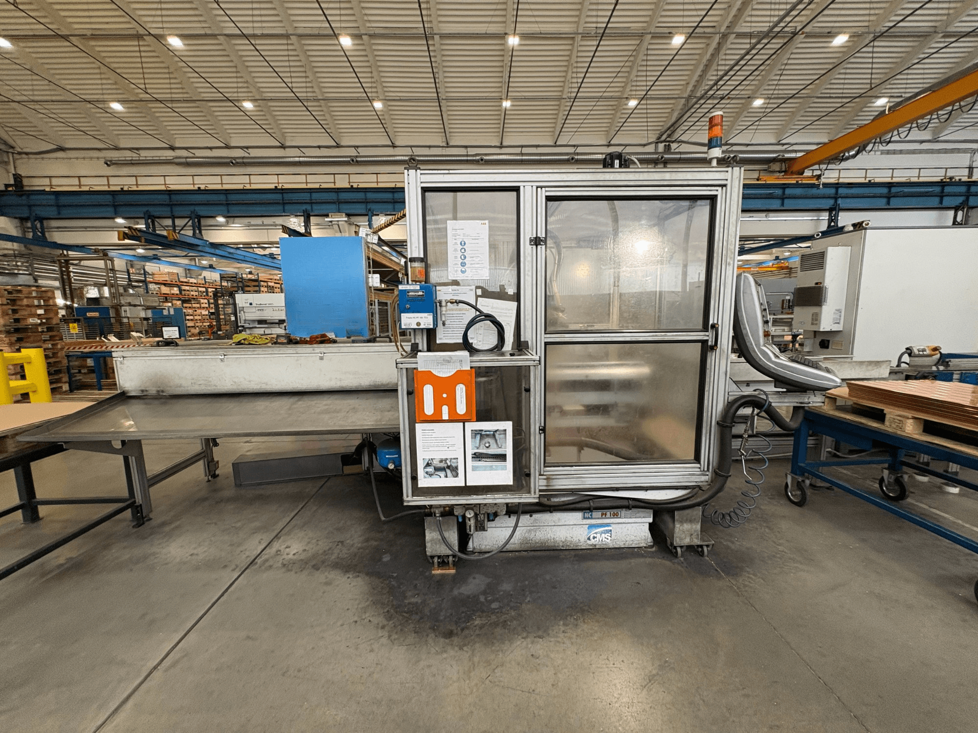 Centro di lavorazione del legno a controllo numerico CMS NC PF 100, vista frontale; dispone di pannello di controllo, cabina di sicurezza e tavolo di lavoro.