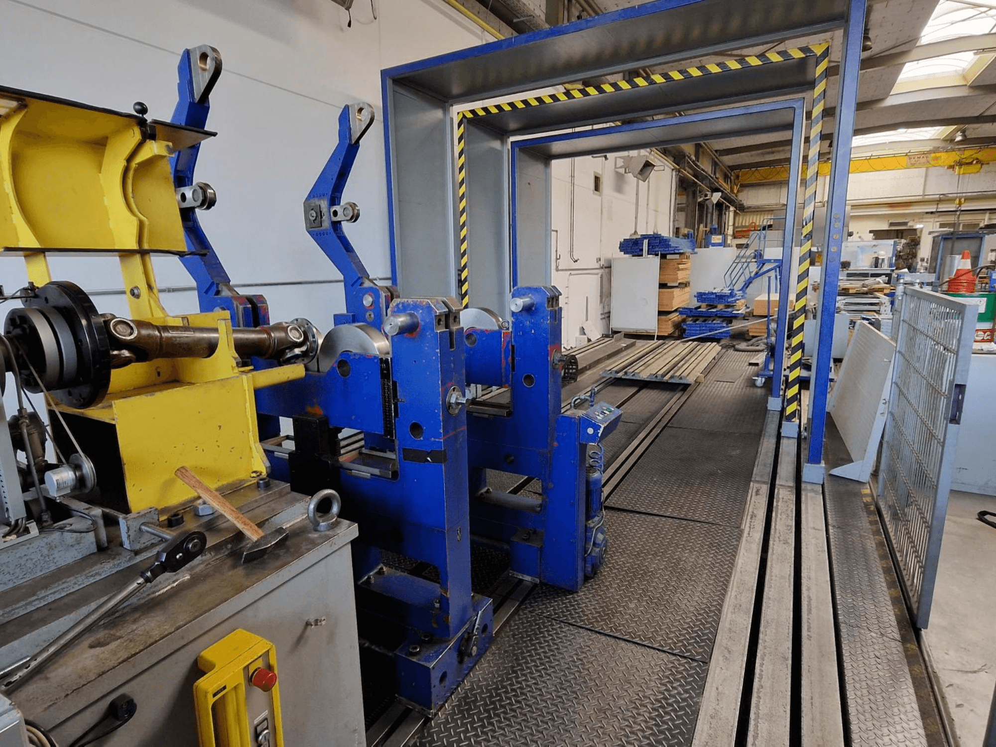 Macchina utensile SCHENCK HM 70U BU, vista laterale che mostra la struttura blu con componenti gialli e il pannello di controllo in un ambiente industriale.