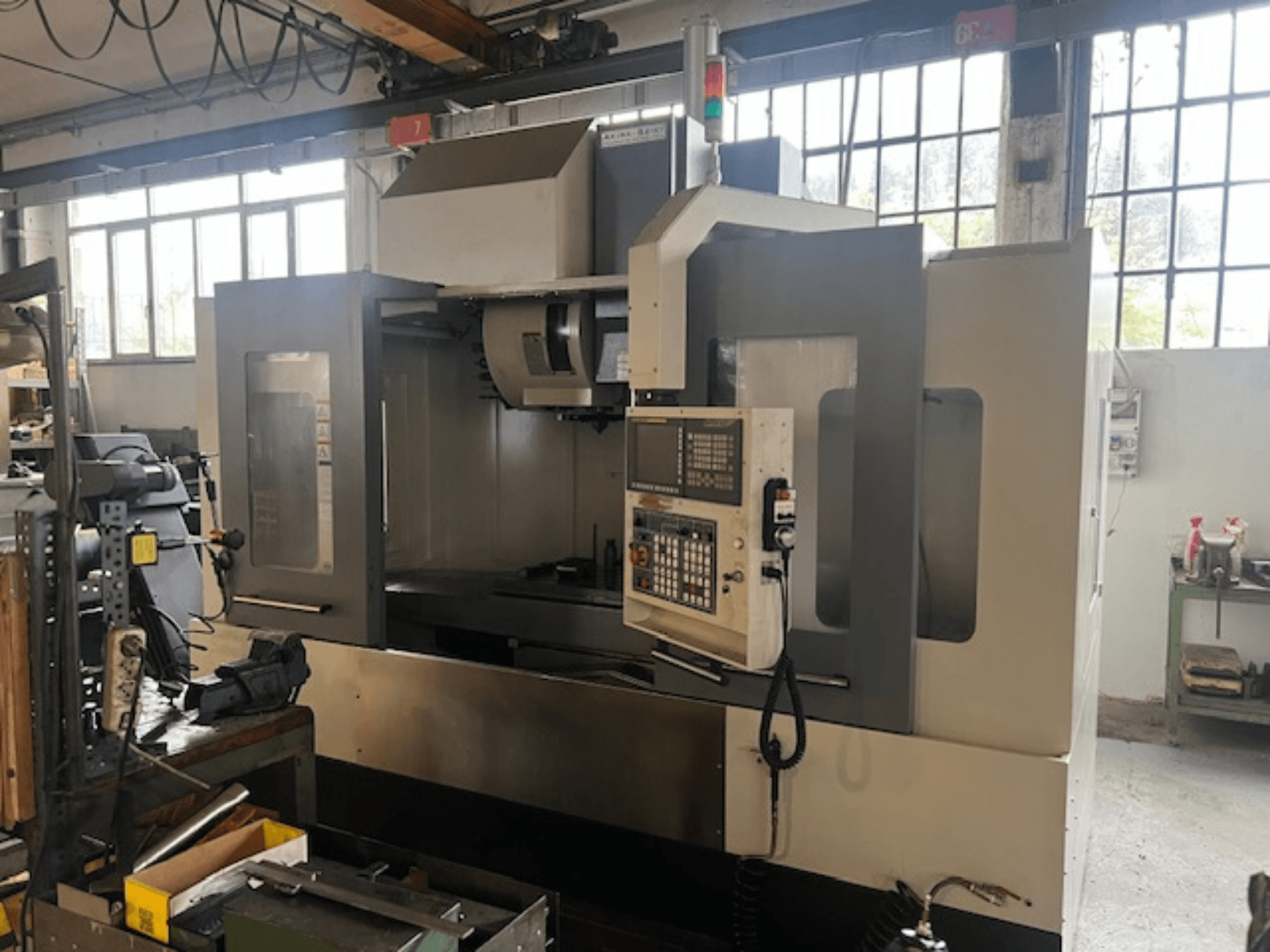 Fresatrice CNC ad alta tecnologia, vista frontale, con comandi digitali, indicatori di sicurezza di base e design compatto.