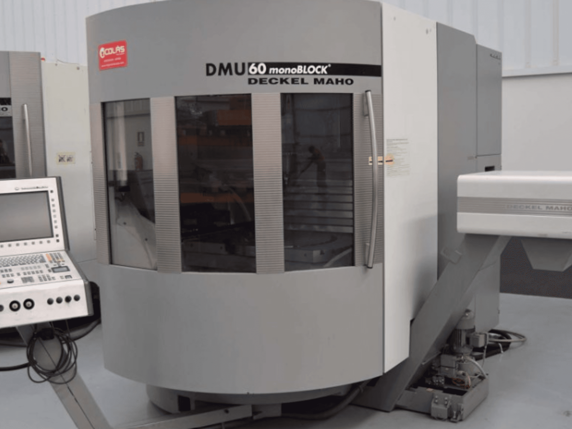 Centro di lavorazione verticale monoblocco DMG DMU60, visto frontalmente con il pannello di controllo visibile sulla sinistra.