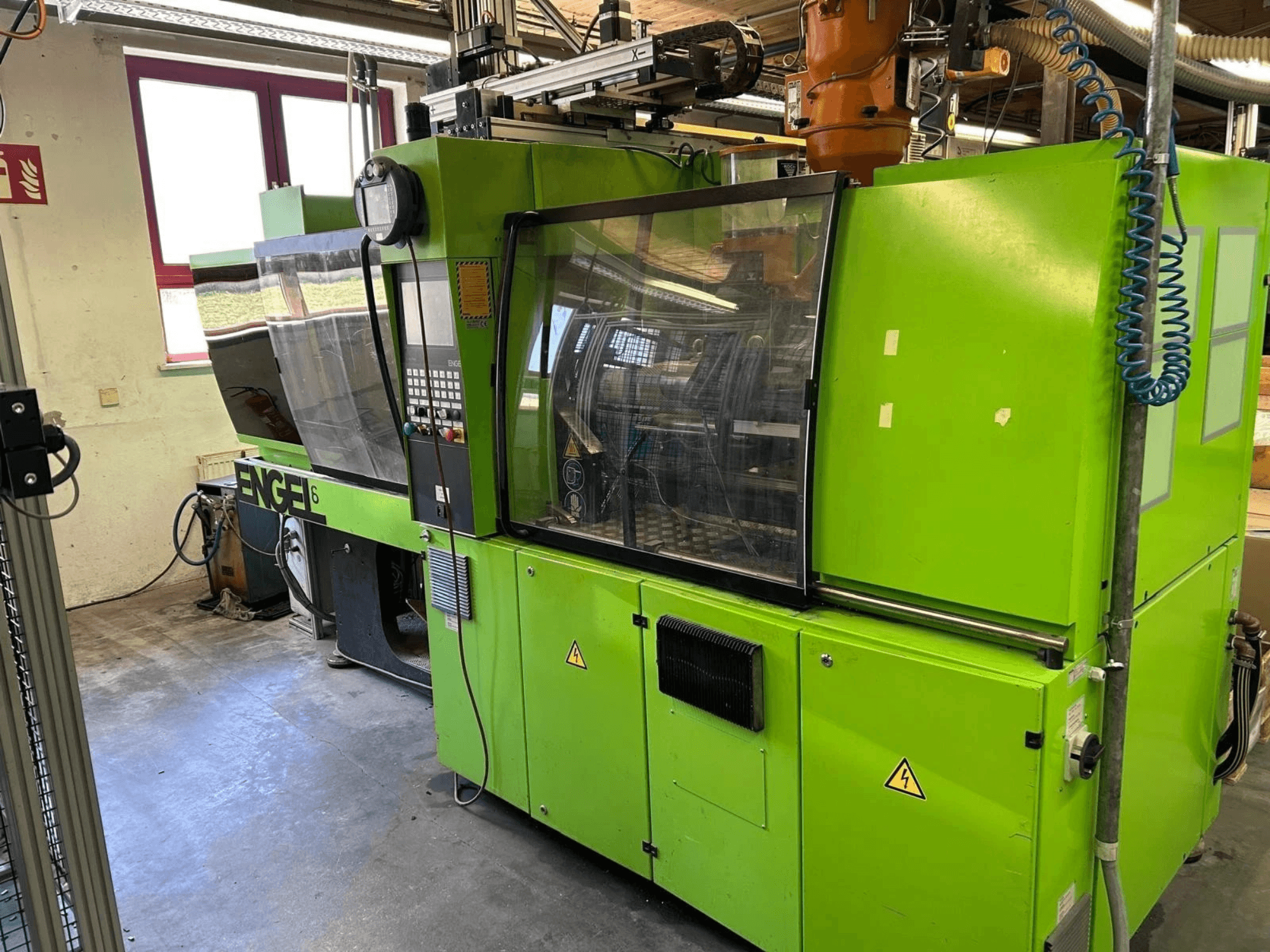 Vista frontale della pressa a iniezione idraulica Engel VICTORY 330/80 Tech, con carrozzeria verde e pannello di controllo.