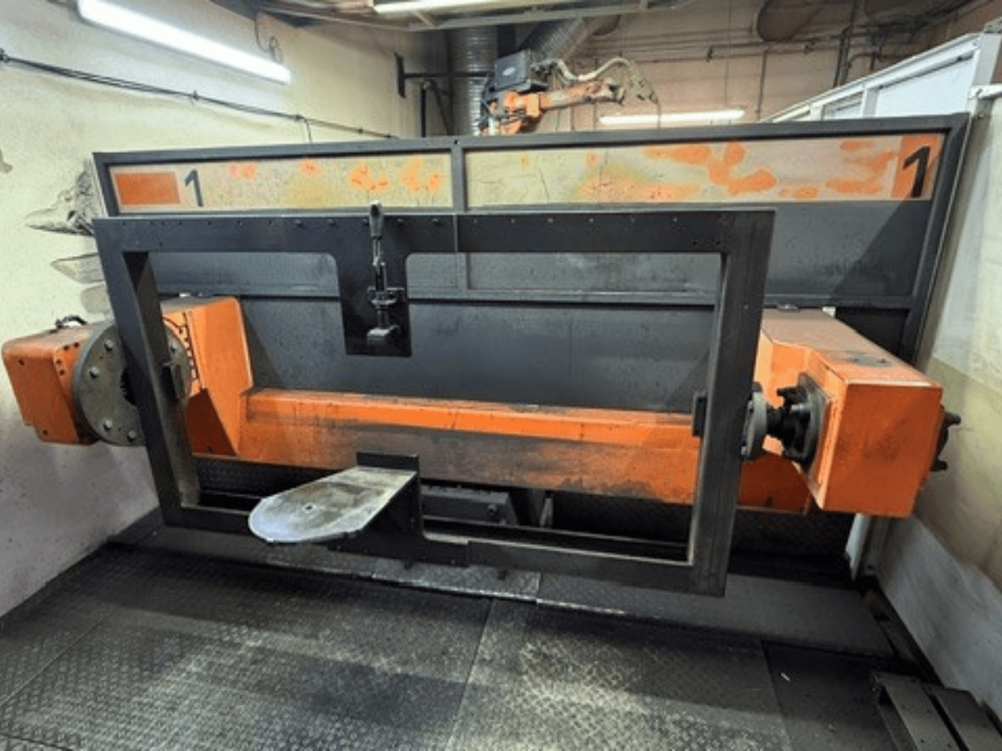 Vista frontale della cella di saldatura ABB IRB 2400L, che mostra un grande telaio robotico con componenti arancioni e neri in un ambiente di officina.