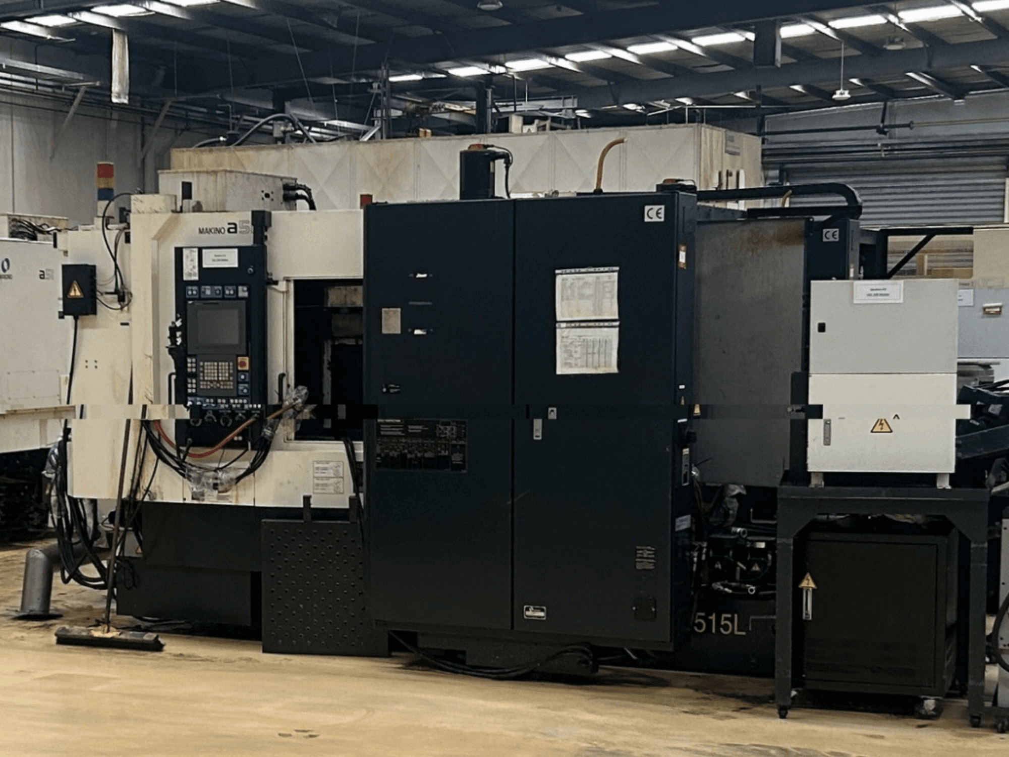 Centro di lavorazione orizzontale Makino A51-5XR, vista frontale che mostra il pannello di controllo, l'alimentatore e i componenti della macchina.