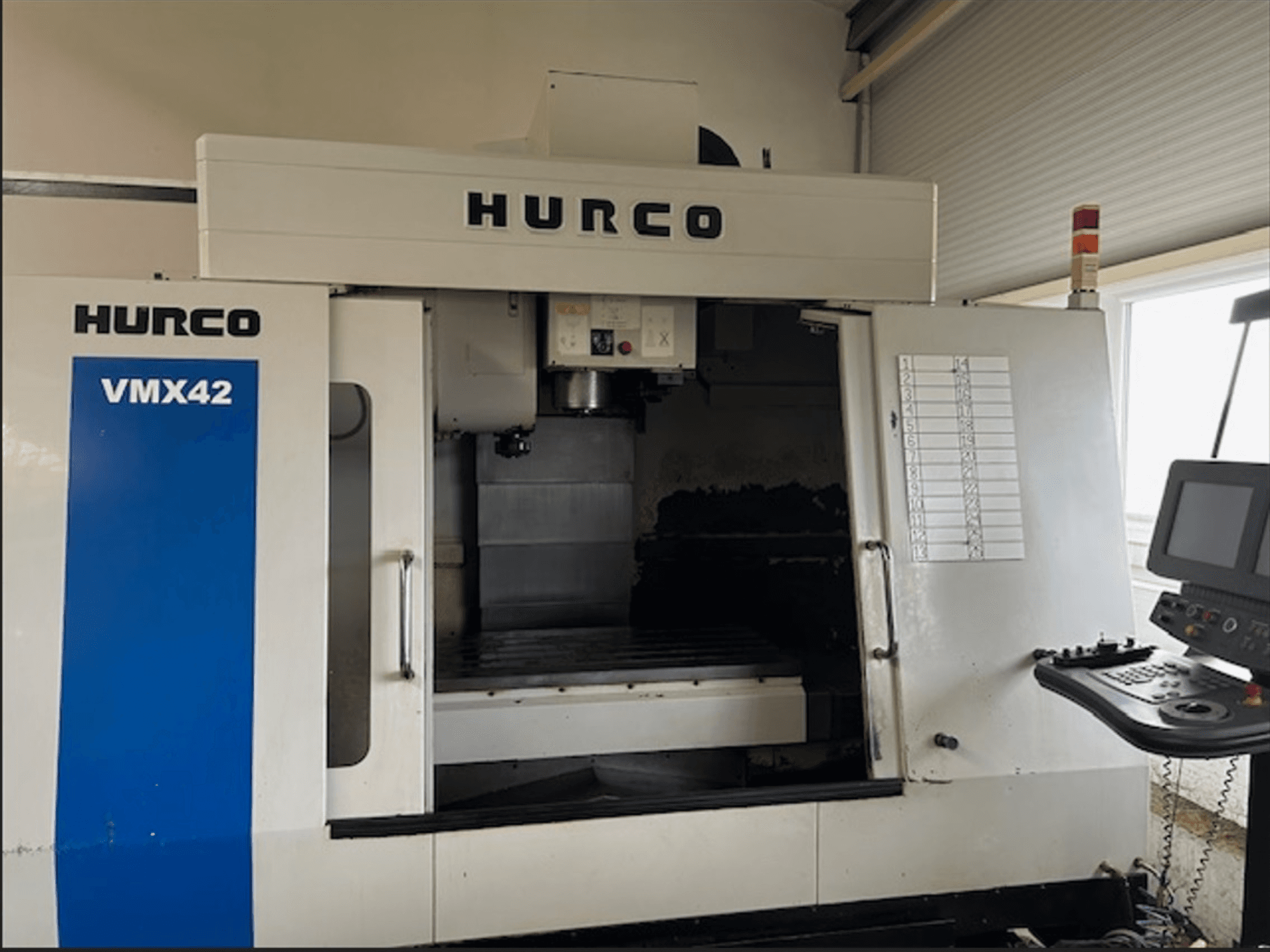 Fresatrice CNC Hurco VMX42, vista frontale, con pannello di controllo e spazio di lavoro aperto per le operazioni di lavorazione.