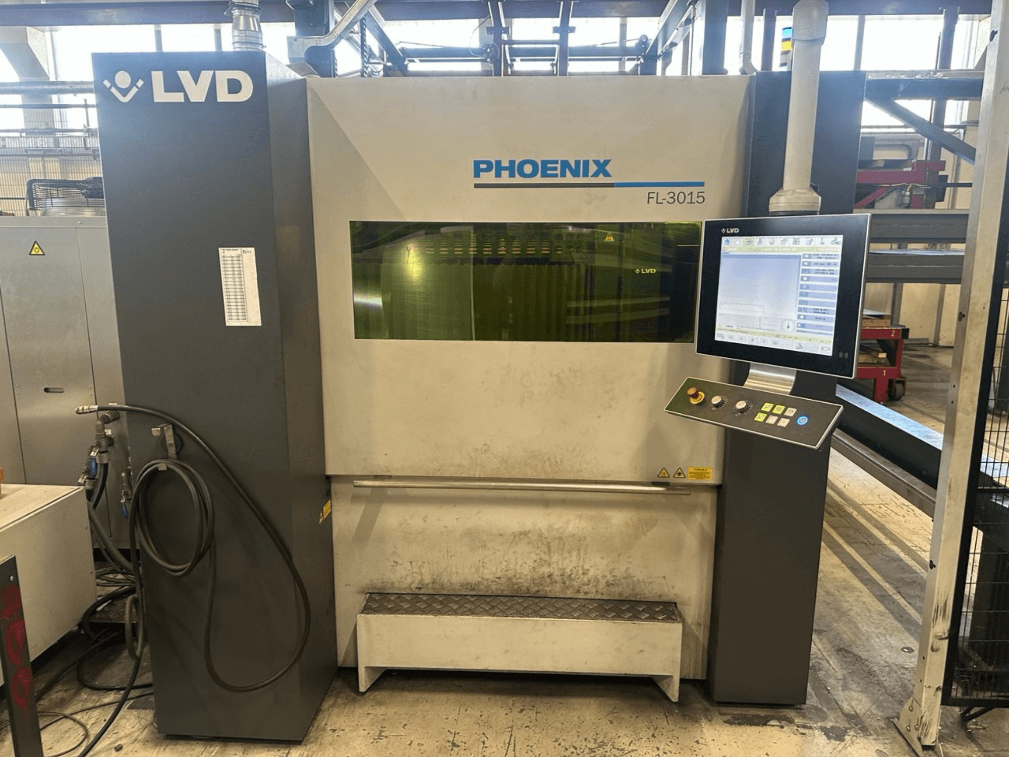 La macchina di taglio laser LVD Phoenix FL-3015, vista frontale, presenta un pannello di controllo digitale e tubi a vista.