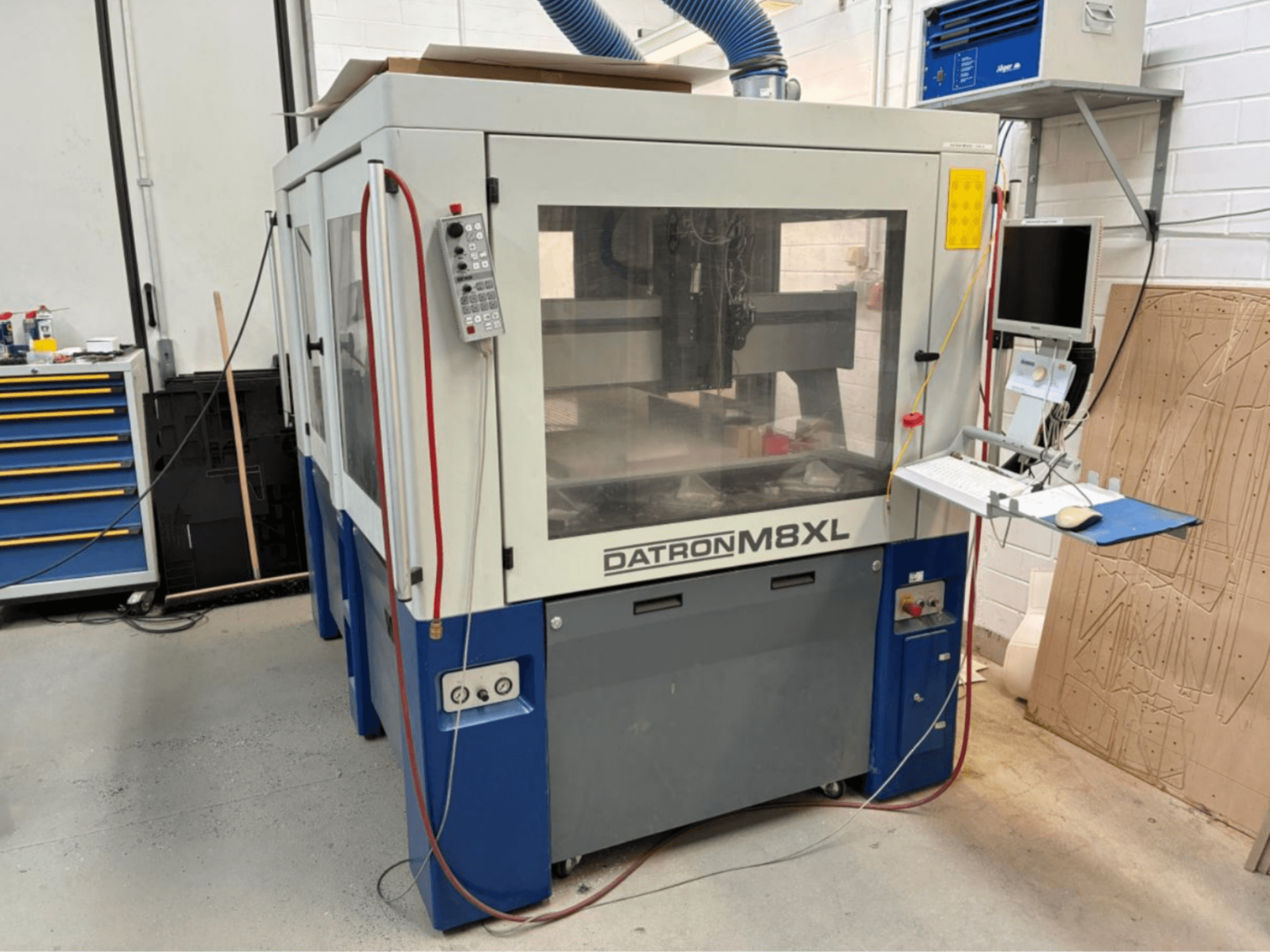 Macchina CNC DATRON M8XL in un'officina, vista frontale con pannello di controllo e monitor montato accanto.