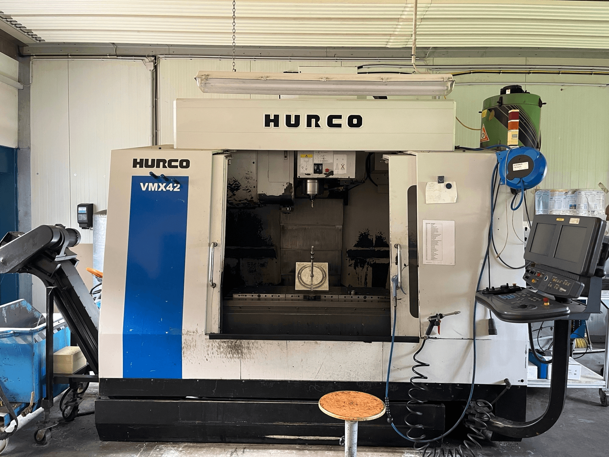 Centro di lavoro verticale Hurco VMX 42 in vista laterale, con pannello di controllo, mandrino e impostazione del pezzo.