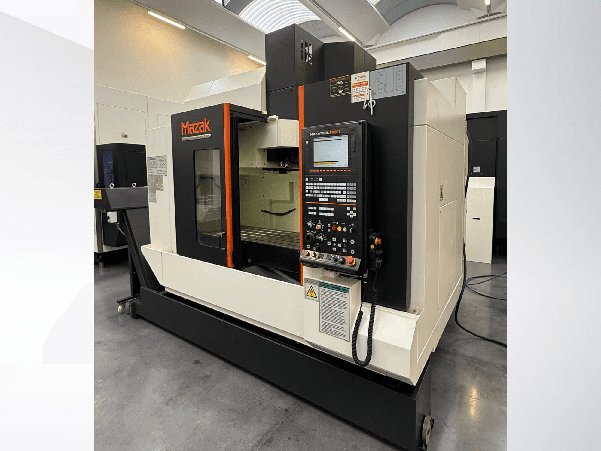 Macchina CNC Mazak, vista frontale, caratterizzata da un pannello di controllo e da un'ampia area di lavoro con utensili di taglio di precisione.