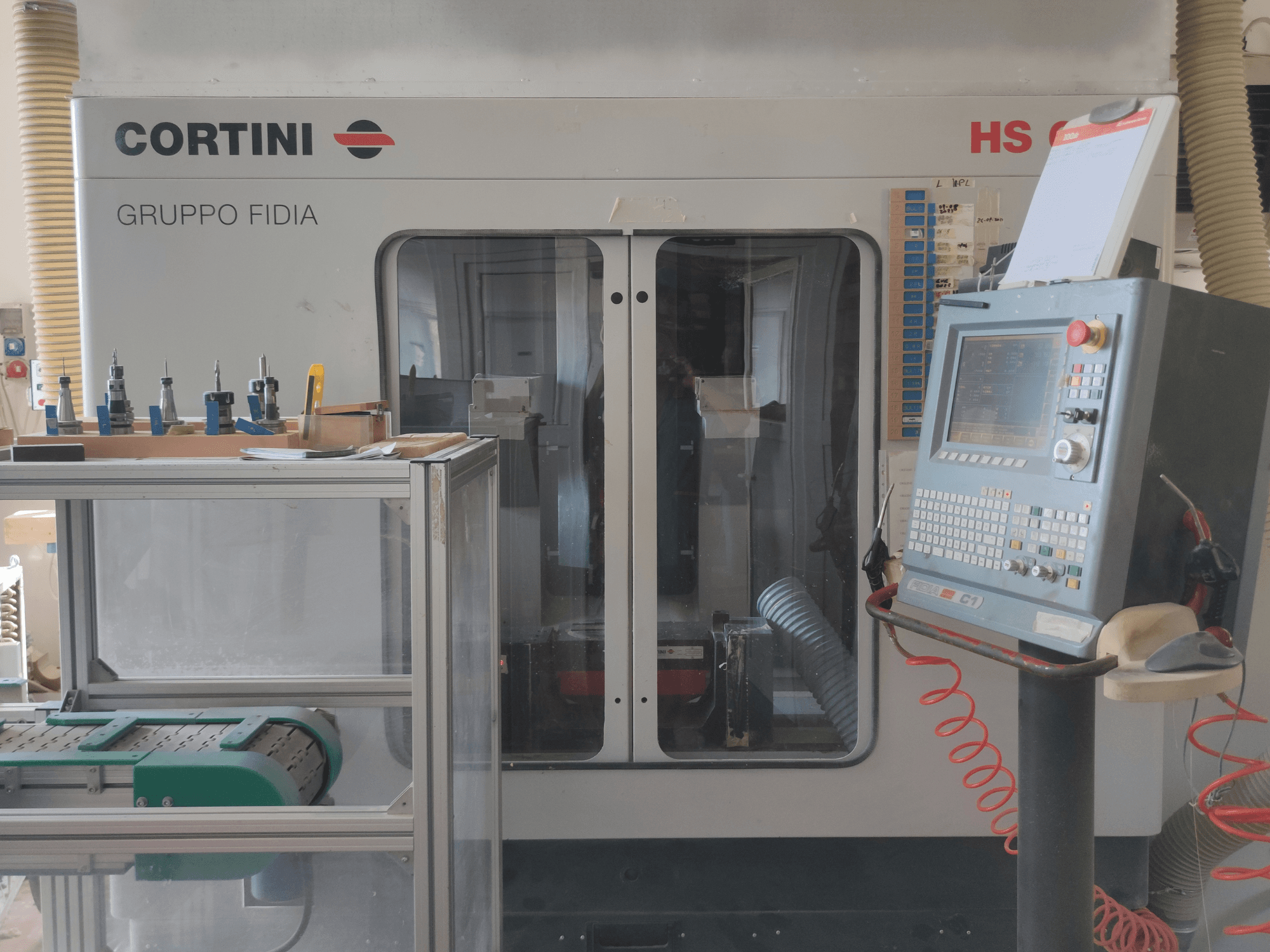 Centro di lavoro verticale CORTINI HS 644 vista frontale, con pannello di controllo, utensili in mostra e componenti del macchinario visibili.