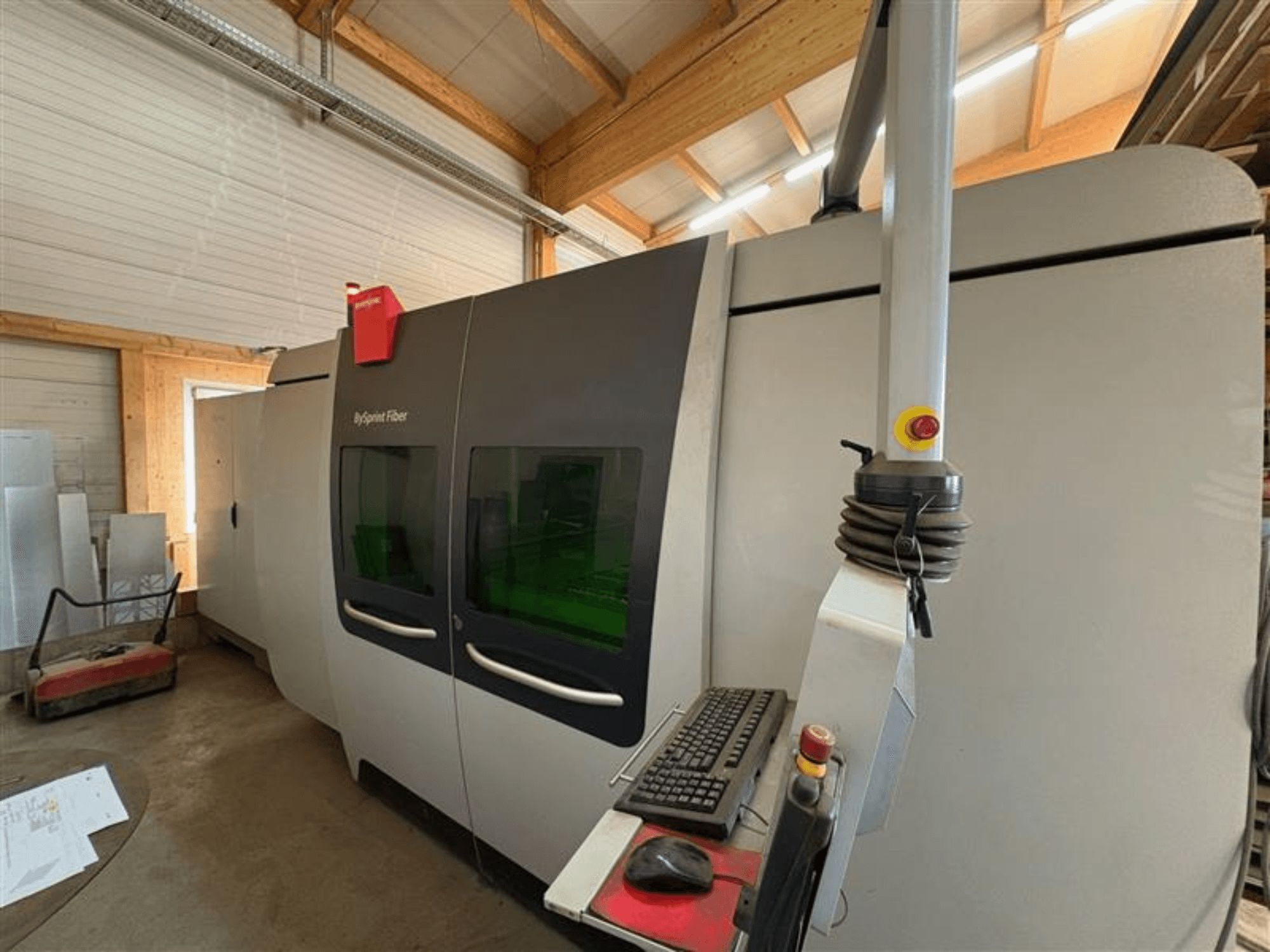 Macchina da taglio Bystronic ByJet Fiber in un'officina, vista frontale che mostra il pannello di controllo e le doppie finestre verdi di visualizzazione.