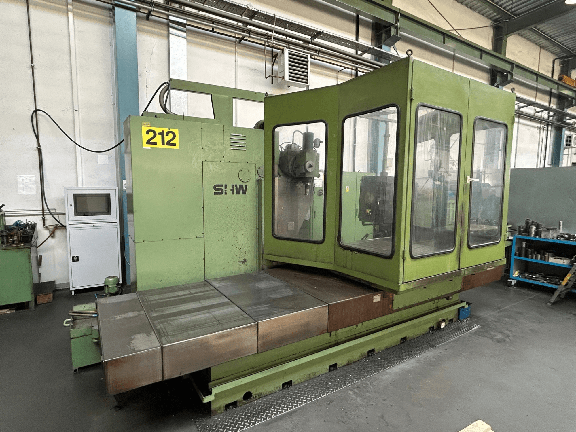 Centro di lavoro verticale SHW UF-5 in verde, vista frontale che mostra il pannello di controllo, l'involucro di vetro e il piano di lavoro in metallo.