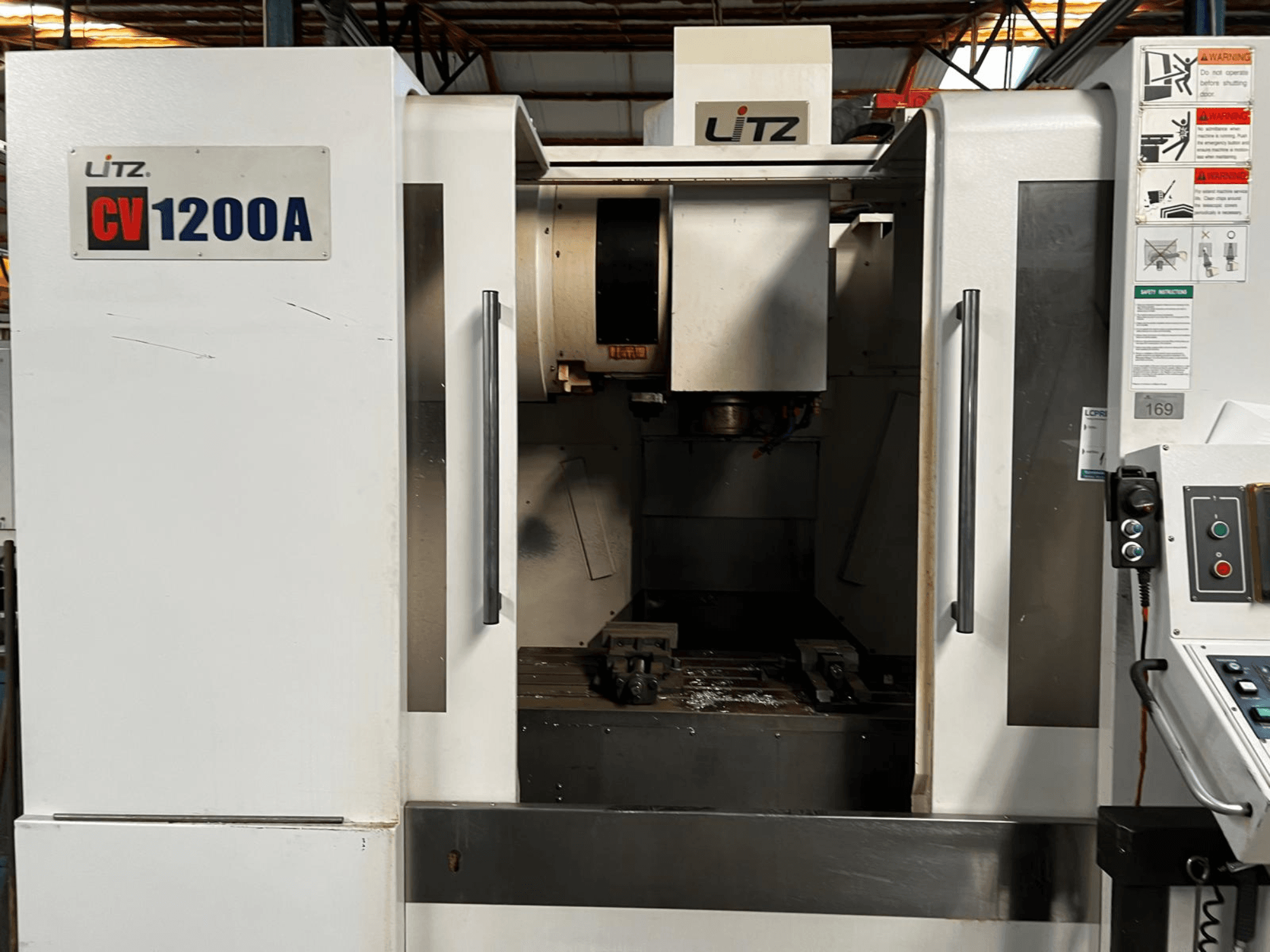 Centro di lavorazione verticale Litz CV1200A, vista frontale, con pannello di controllo, mandrino e porta aperta che mostra l'area di lavoro.
