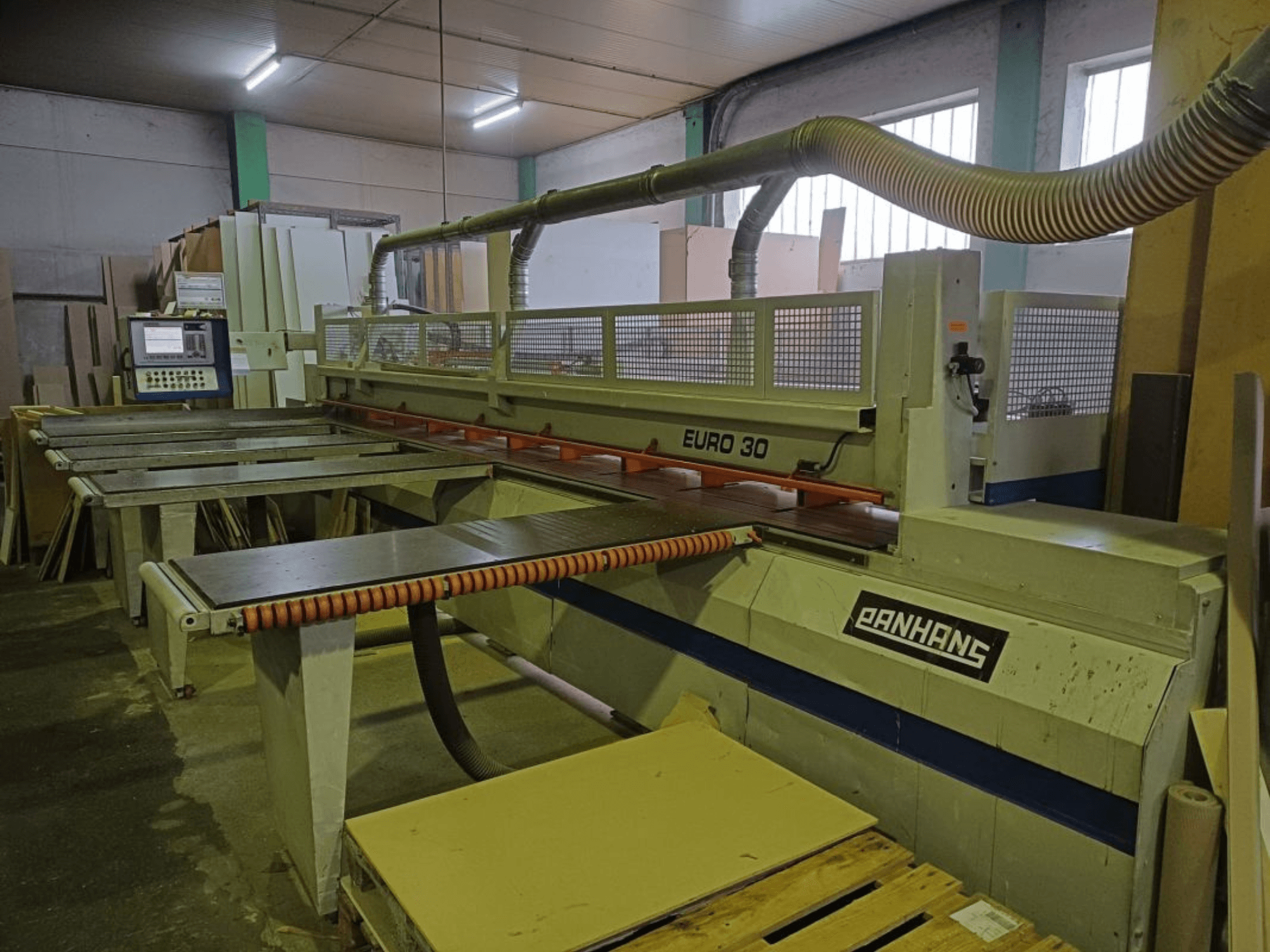 Vista frontale della sezionatrice PANHANS EURO 30 con pannello di controllo, tavolo di taglio e tubo di aspirazione in un'officina.