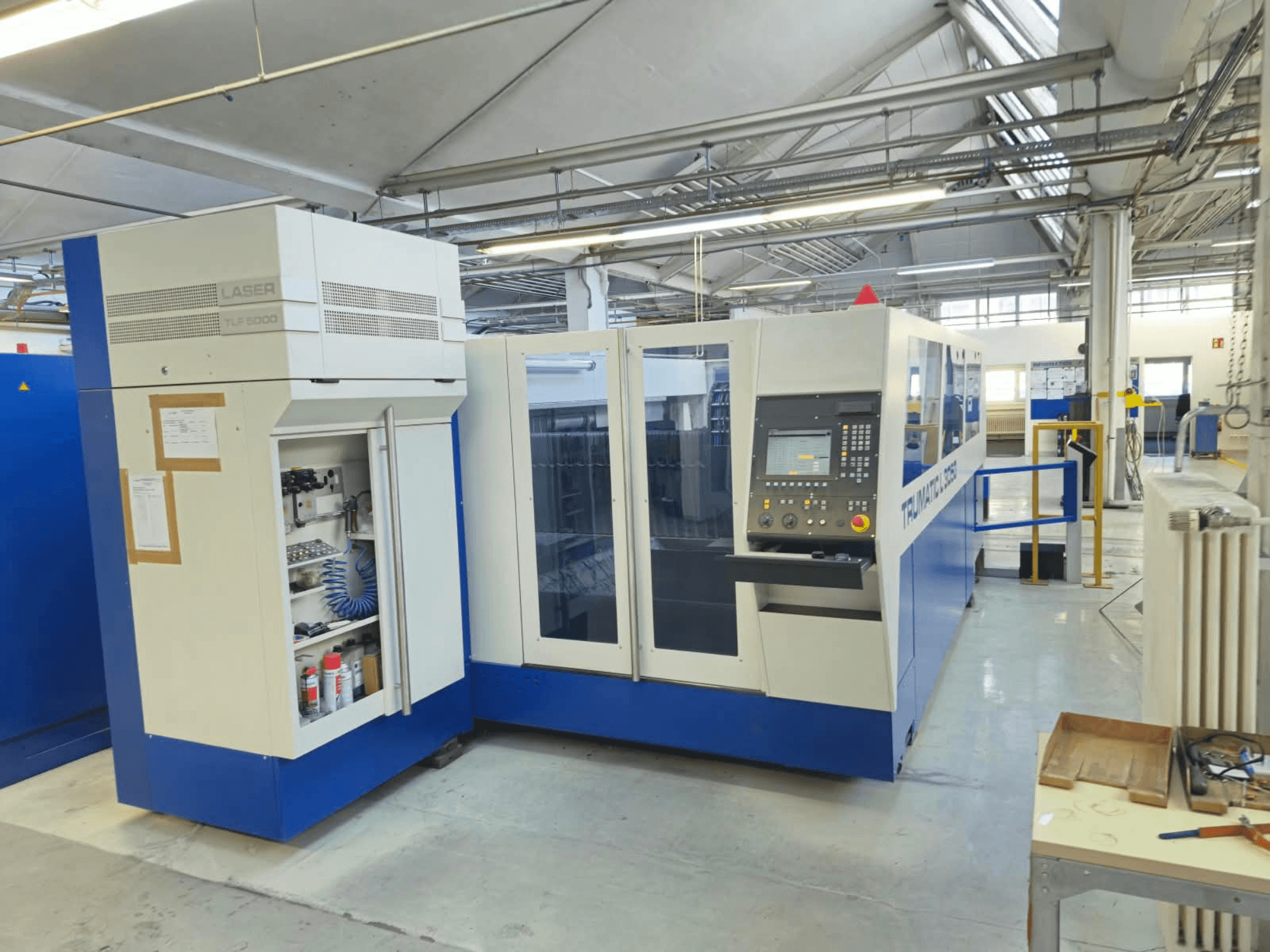 Macchina da taglio laser a CO₂ TRUMPF TruLaser L3050, vista frontale, con pannello di controllo e sportello di accesso per la manutenzione, in ambiente di fabbrica.