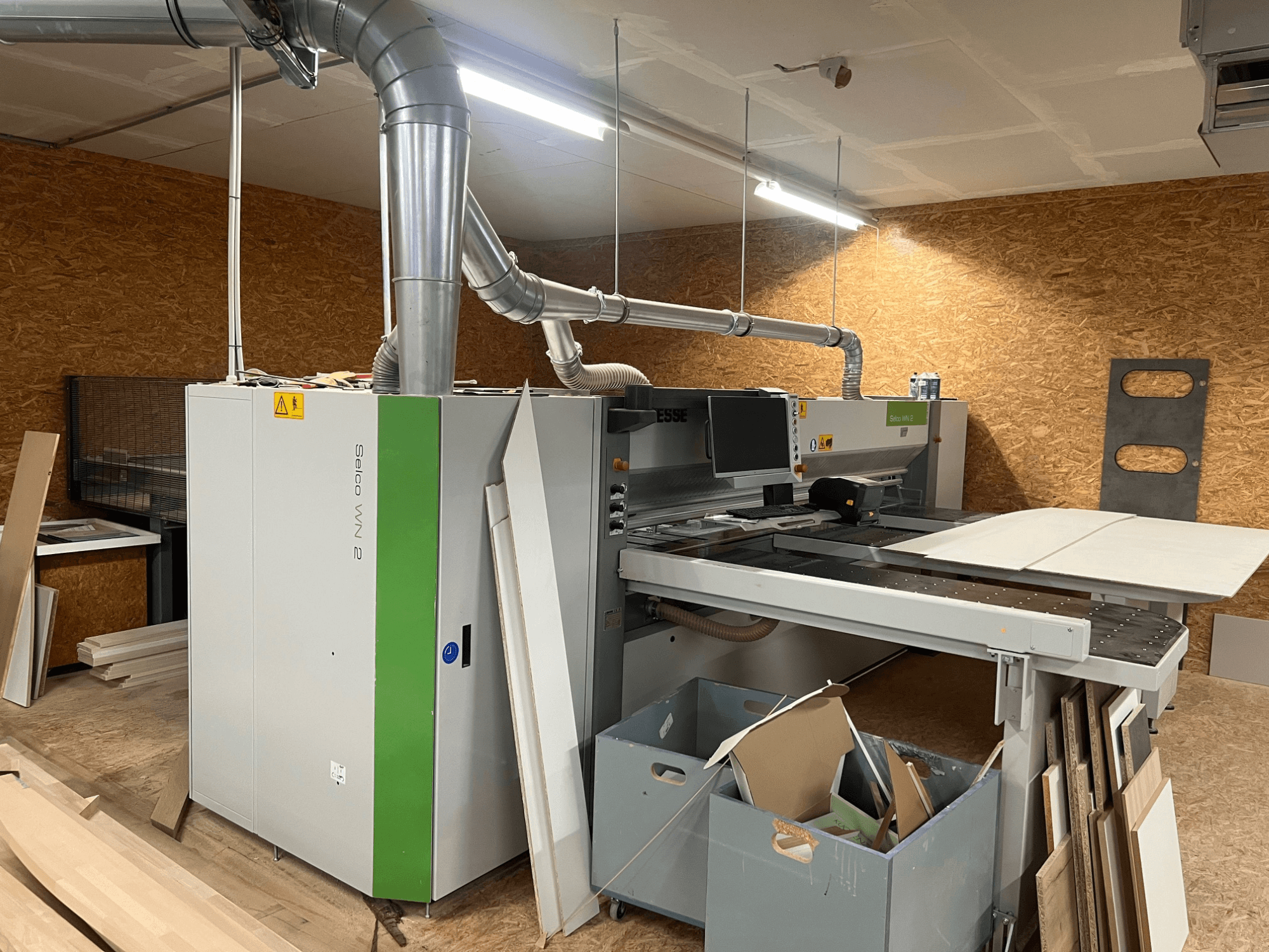 Sezionatrice BIESSE Selco WN 2 in un'officina, con ampio tavolo di taglio e sistema di aspirazione della polvere, vista laterale.