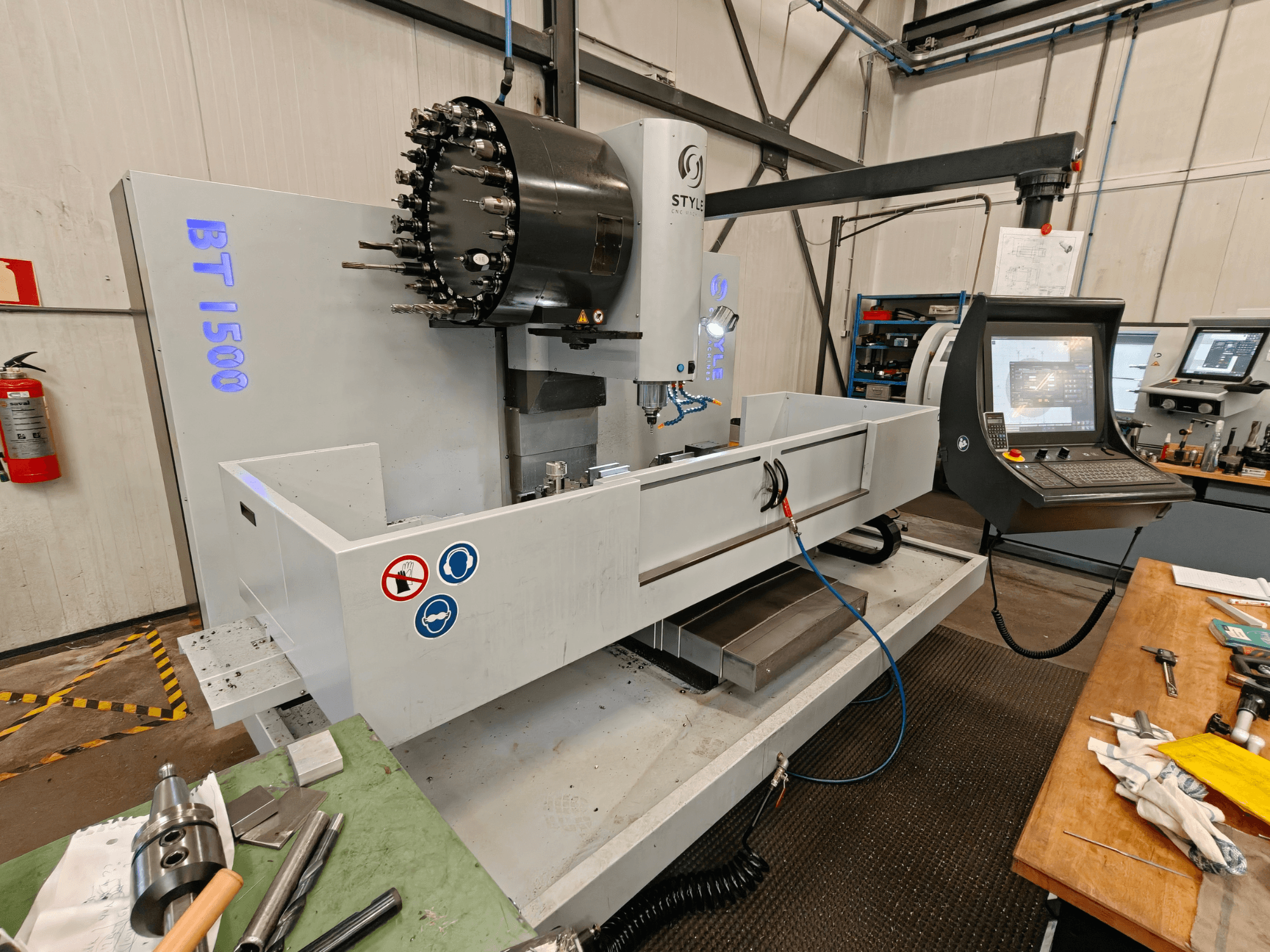 Centro di lavoro verticale STYLE BT 1500 in un'officina, con pannello di controllo, portautensili e area di lavoro.
