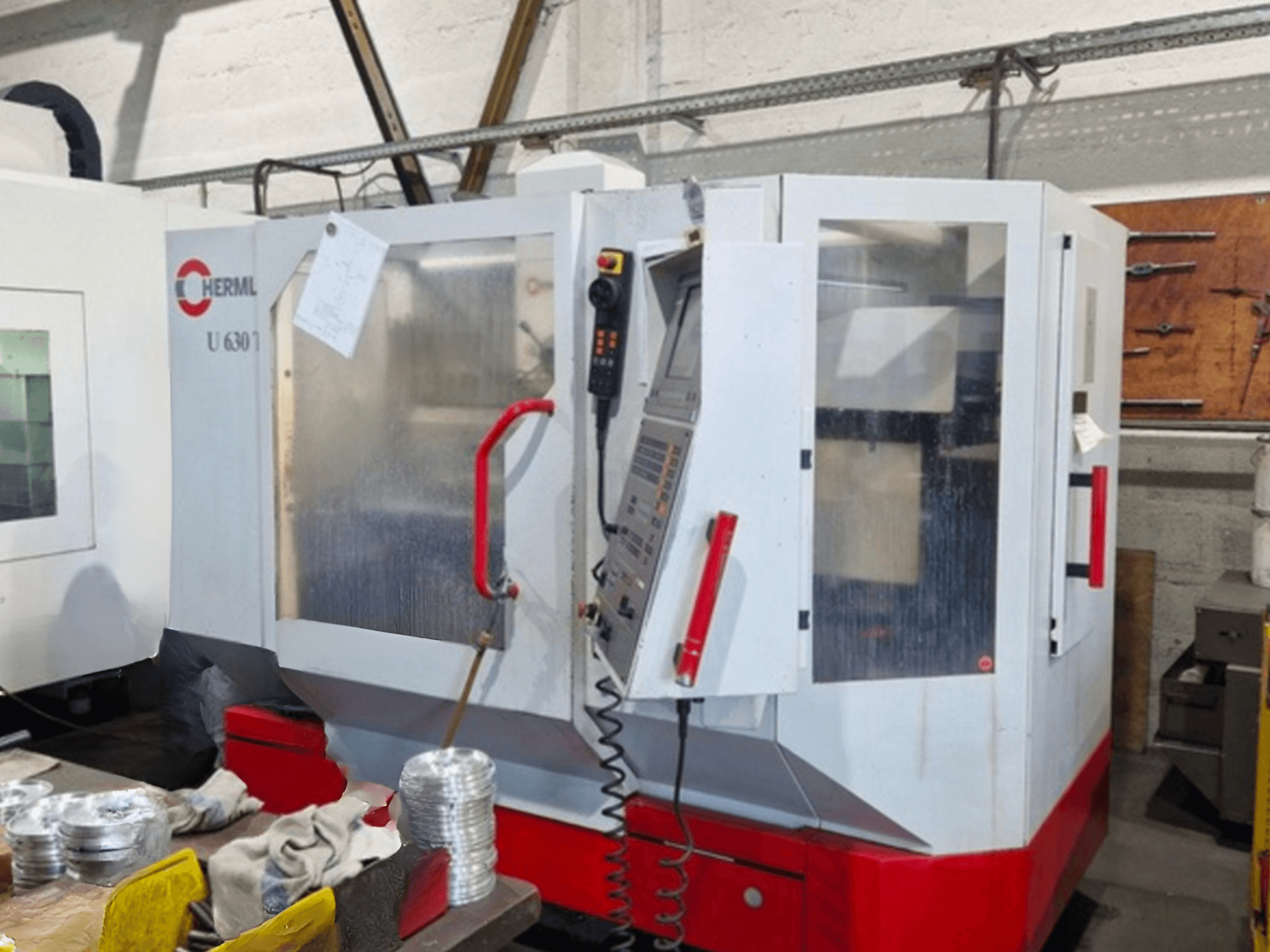 Centro di lavoro universale HERMLE U 630 T in vista frontale, con porta aperta e pannello di controllo con pulsanti e utensili visibili.