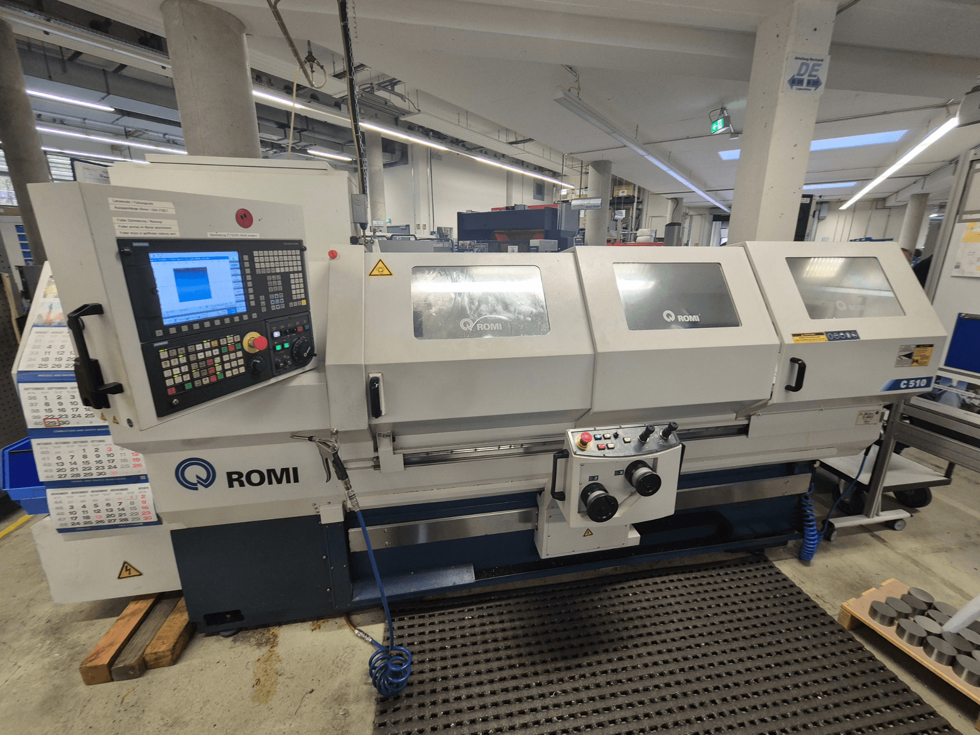 Tornio Romi C510 visto frontalmente, con pannello di controllo digitale e tre coperture di protezione. Include etichette di sicurezza.