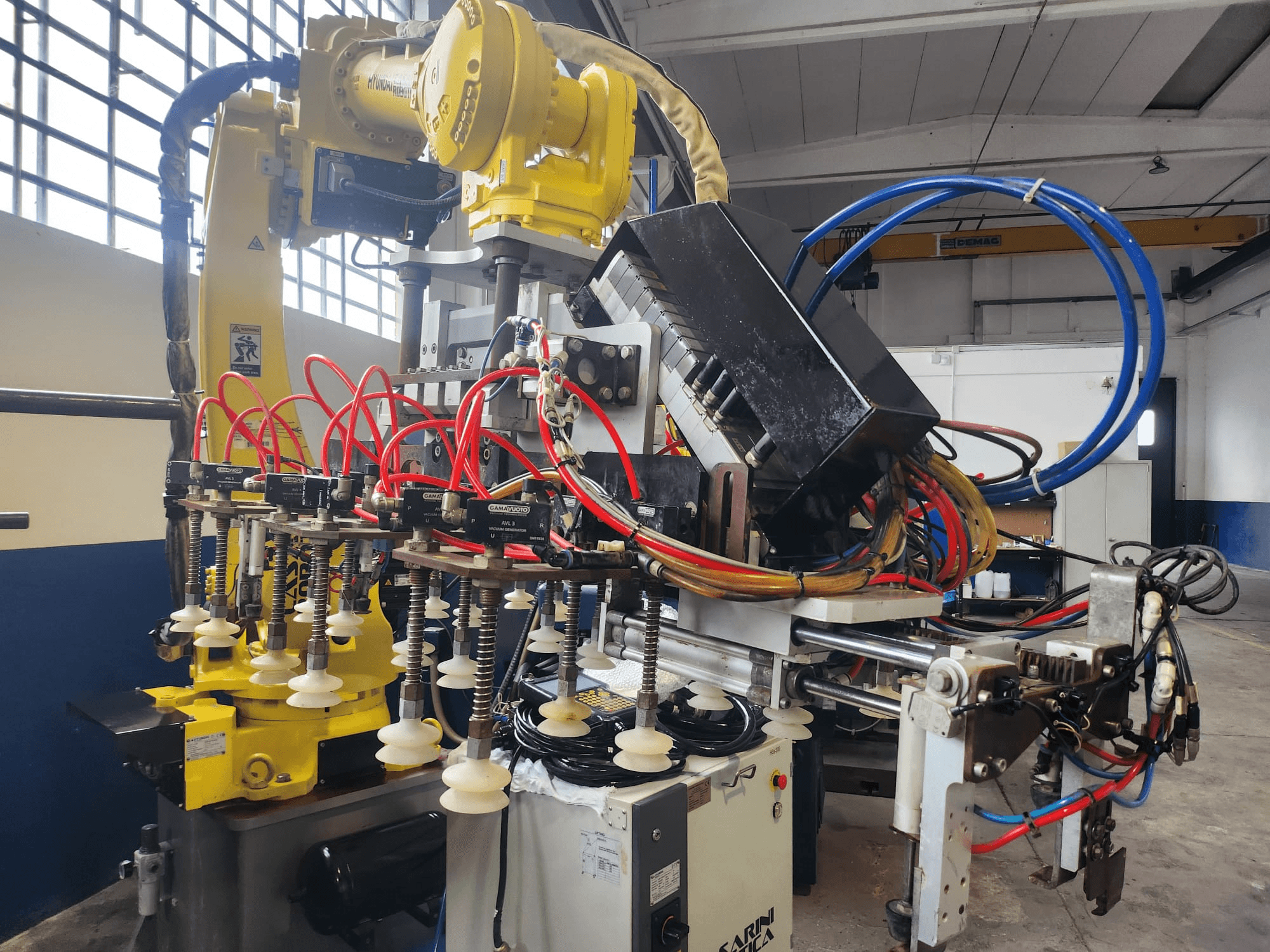 Braccio robotico Hyundai Hi 5a-S visto frontalmente, con diversi tubi, componenti di controllo e una complessa disposizione di cavi.