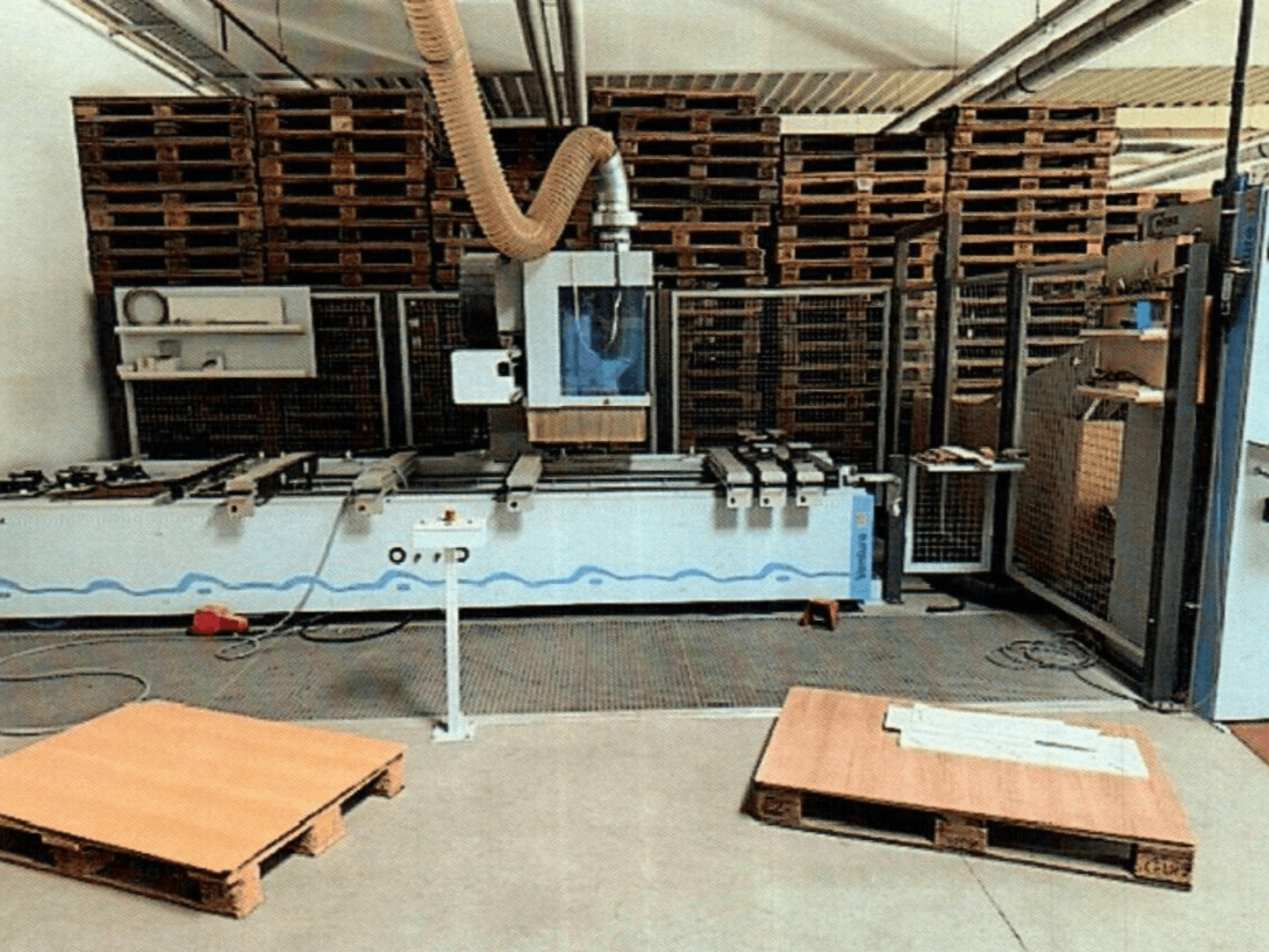 Centro di lavorazione del legno a CNC Weeke Venture 1M in un'officina, vista frontale con pallet di legno visibili e allestimento industriale.