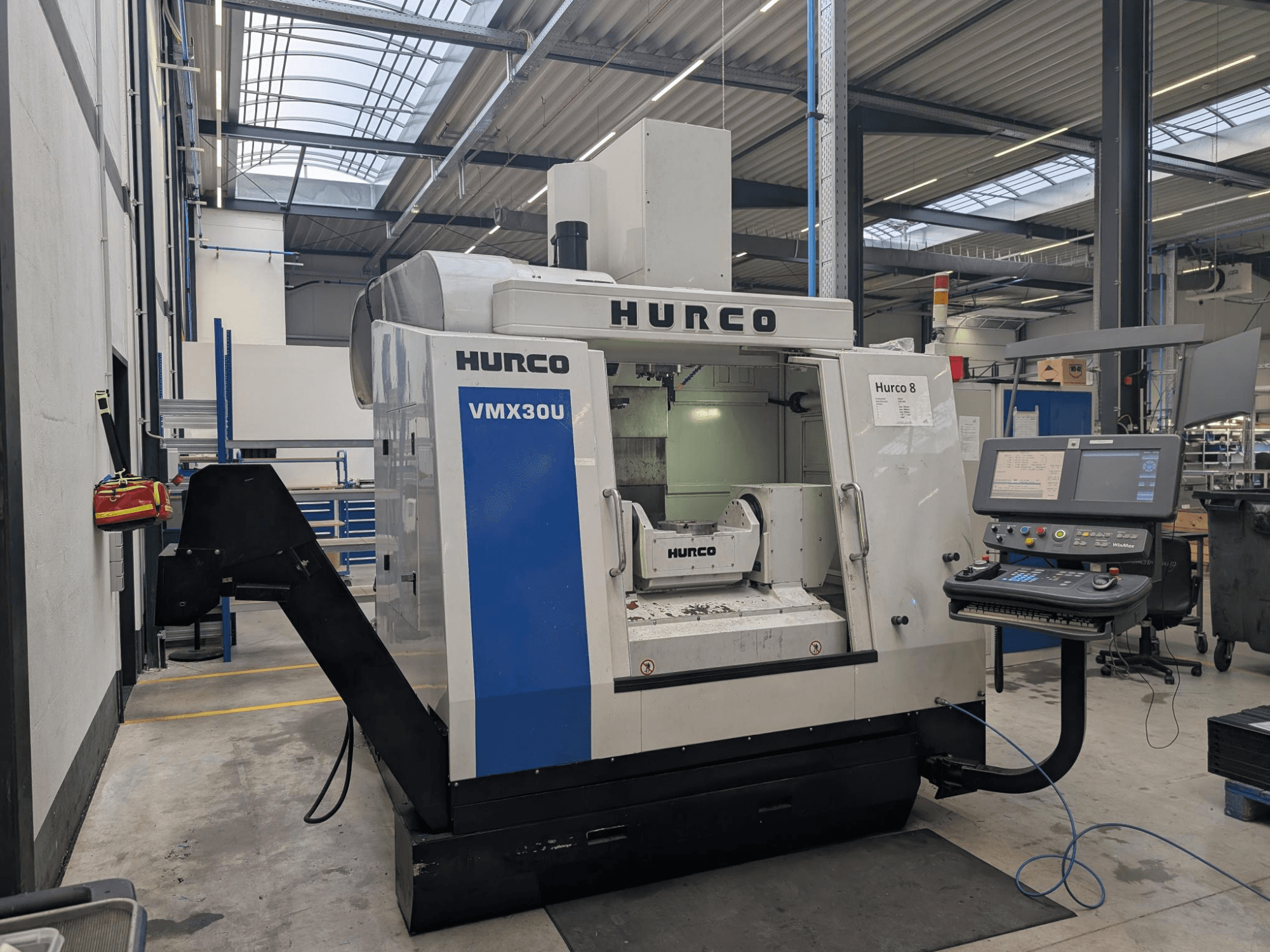 Macchina CNC Hurco VMX30U in officina, vista frontale, con pannello di controllo con pulsanti e display dati.