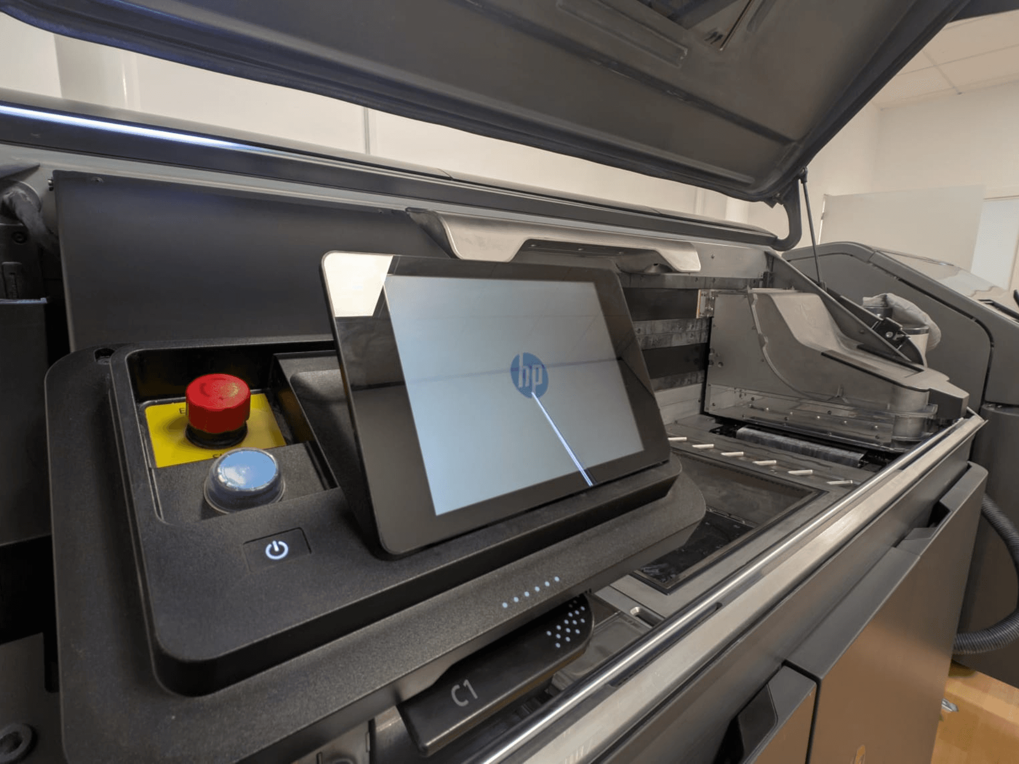 Pannello di controllo della stampante HP che mostra il display della tavoletta, i pulsanti rossi e blu e una vista laterale dei componenti interni della stampante.