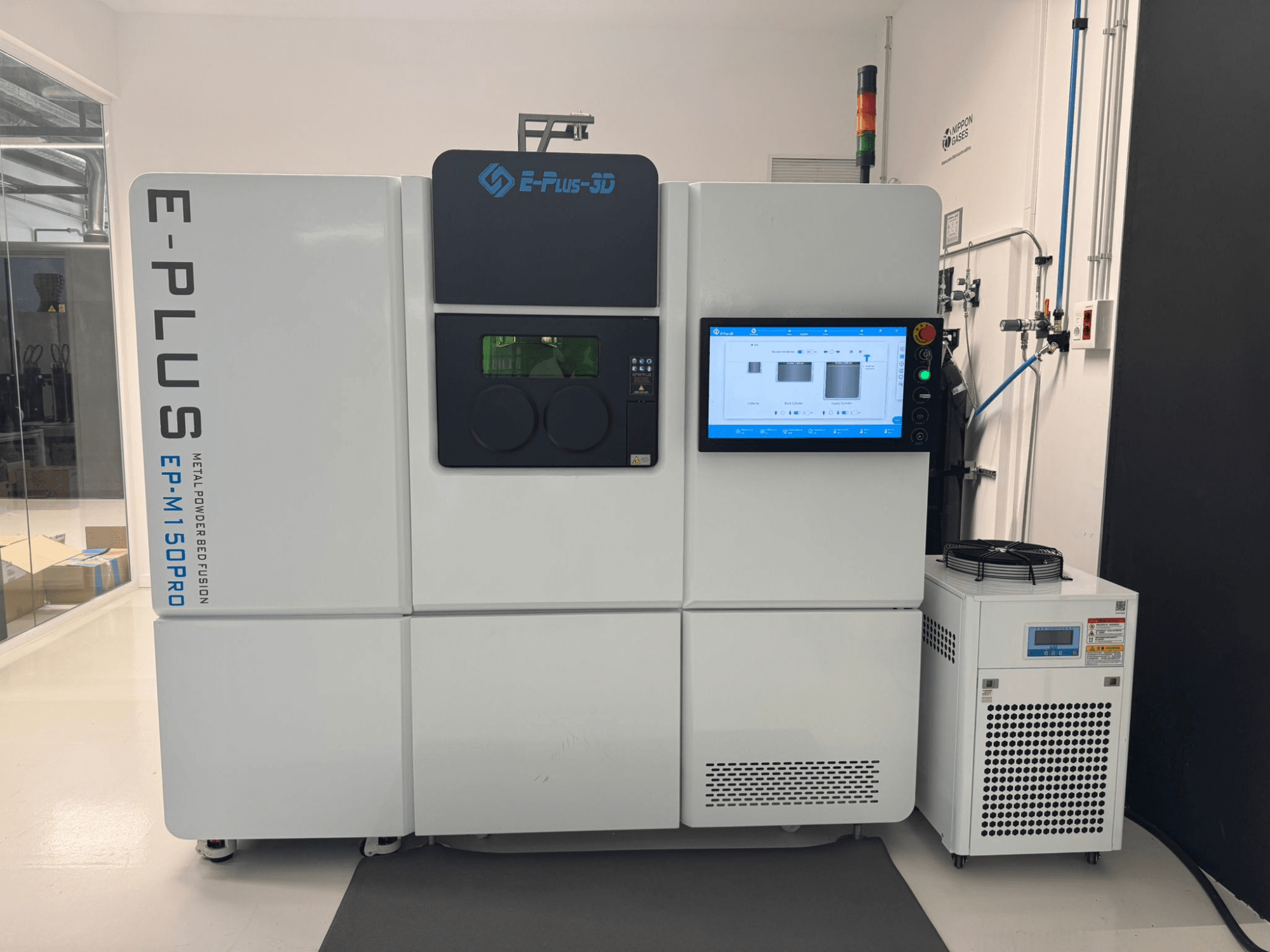 Vista frontale della stampante 3D in plastica Eplus3D EP-M150Pro con display touchscreen e unità di raffreddamento in uno spazio di lavoro pulito e ben illuminato.