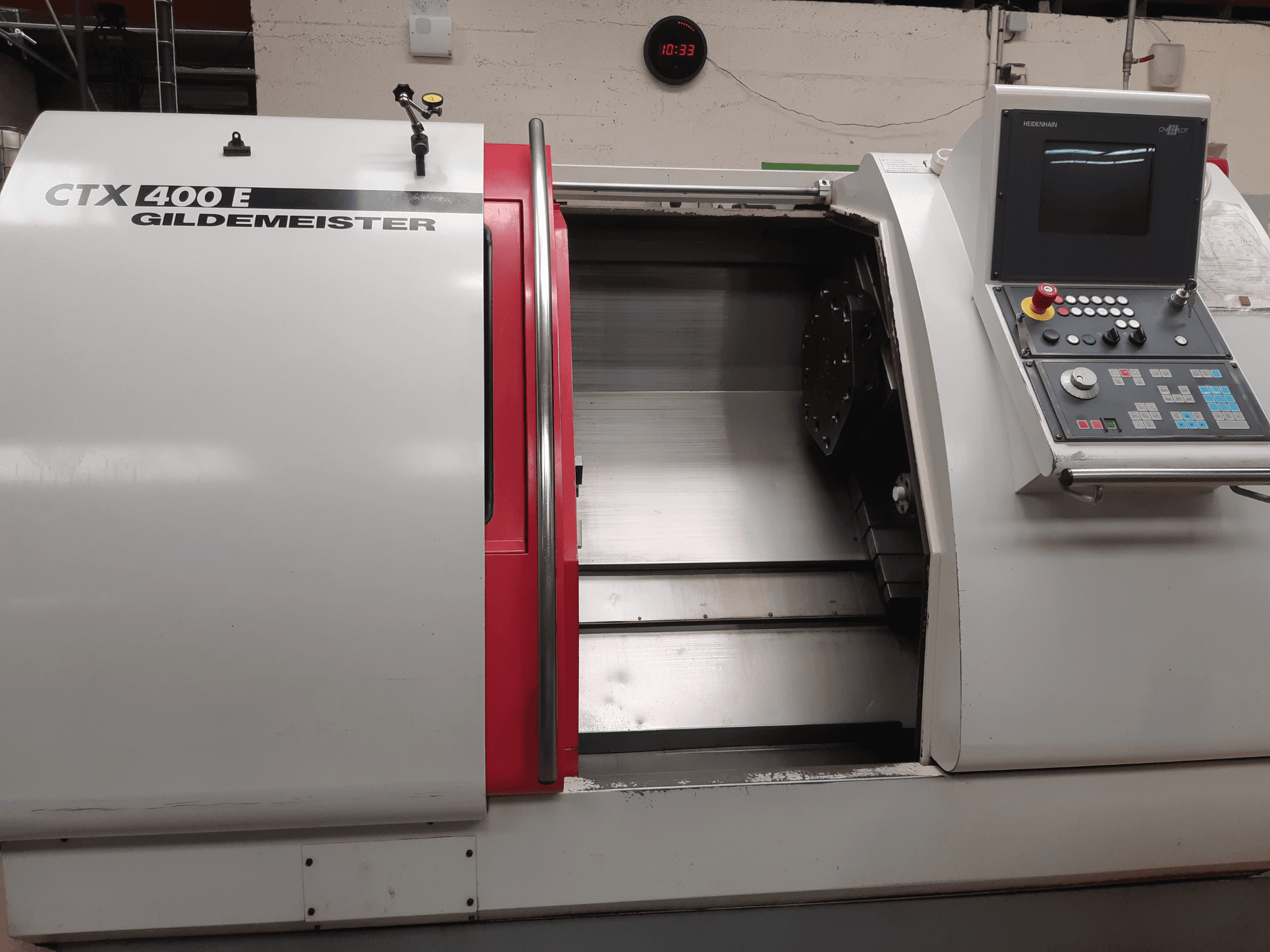 Tornio orizzontale Gildemeister CTX 400 E ripreso di profilo, con in primo piano il pannello di controllo e la parte anteriore aperta per consentire l'accesso agli utensili.