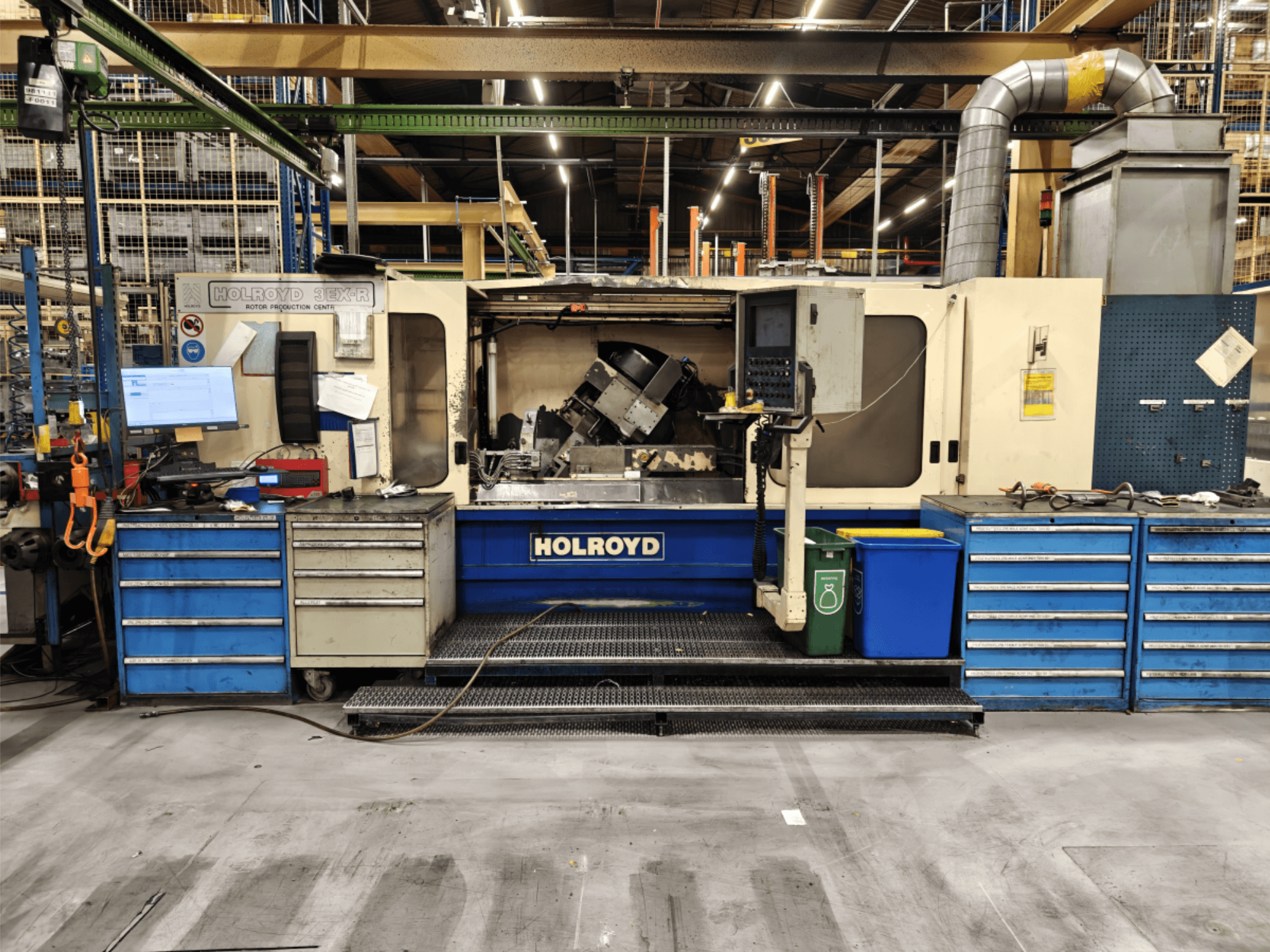 Macchina utensile Holroyd 3EX-R in un'officina, vista frontale, che mostra il pannello di controllo, il magazzino utensili e l'area di lavoro interna.