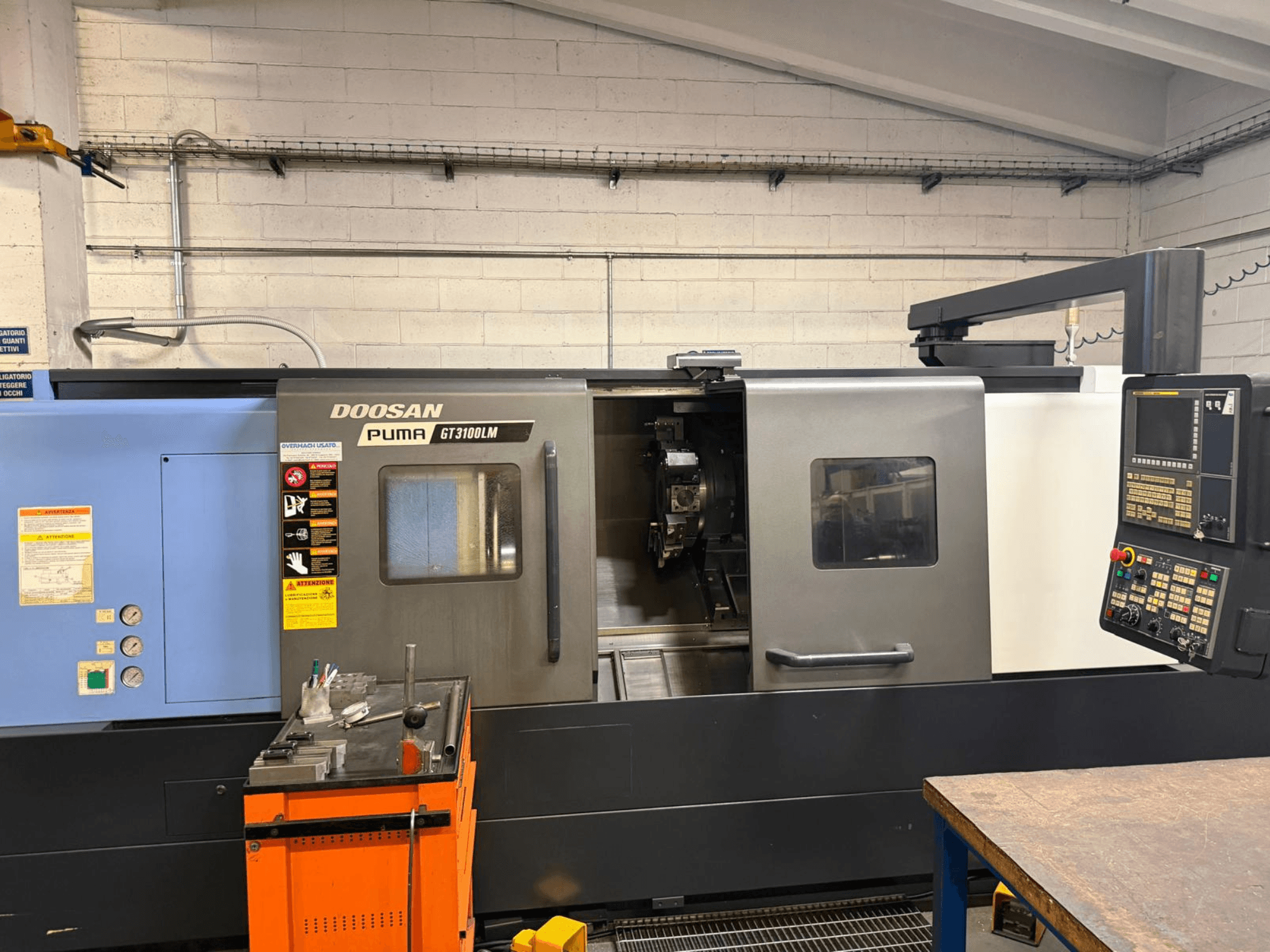 Vista frontale del tornio orizzontale DOOSAN PUMA GT3100LM, che mostra il pannello di controllo e l'area di lavoro con gli utensili.