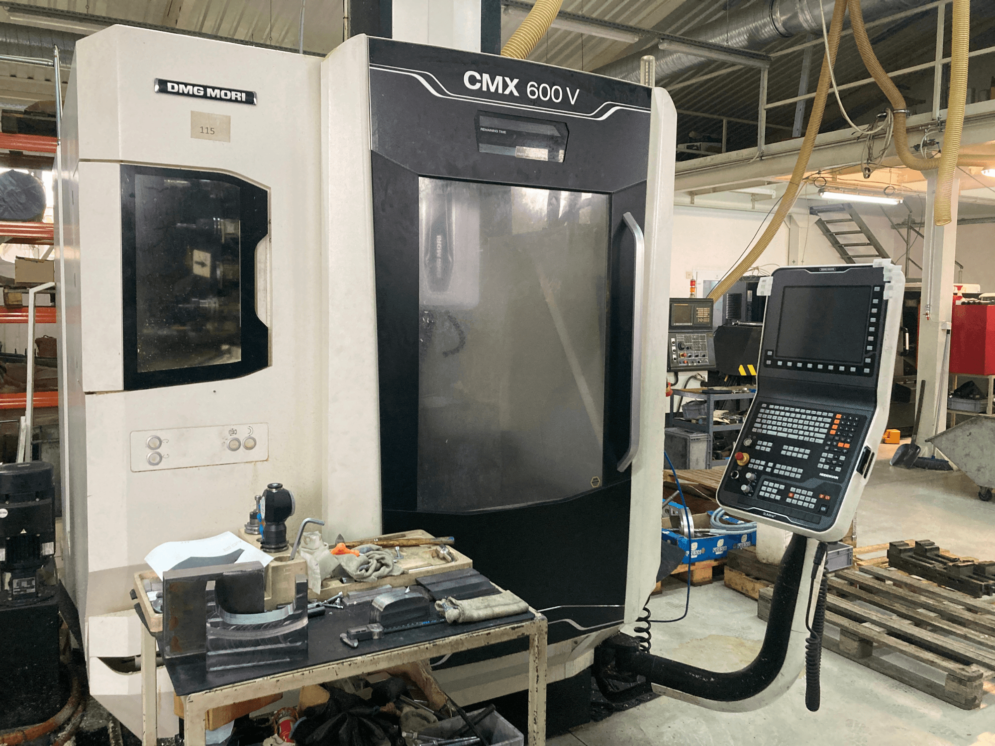 La fresatrice DMG MORI CMX 600 V vista frontalmente, con il pannello di controllo e il piano di lavoro con gli utensili.