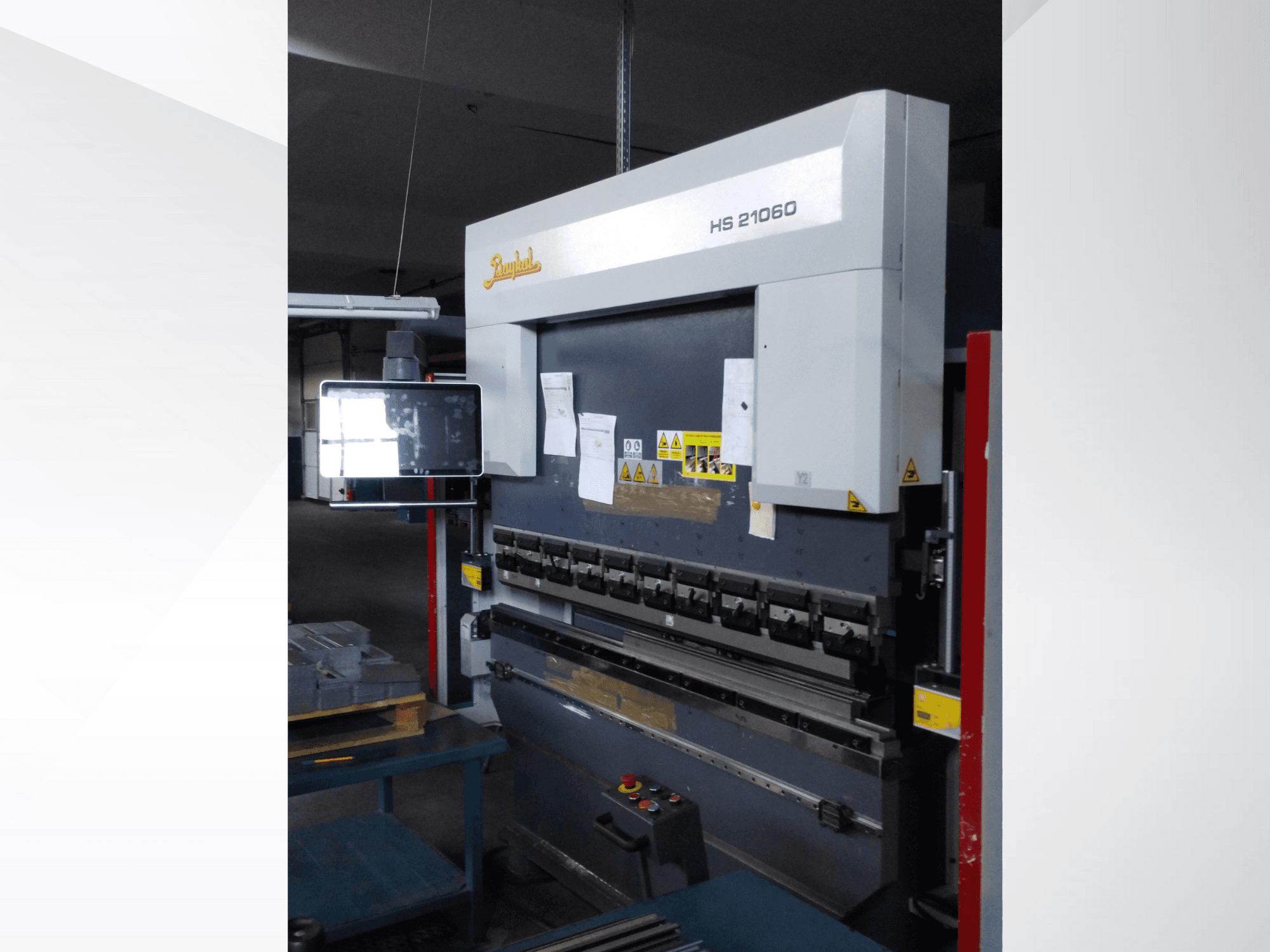 Pressa piegatrice Beyeler HS 21060, vista frontale, con comandi, display ed etichette di avvertimento in un'officina.