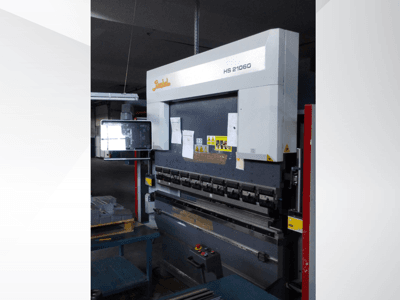Pressa piegatrice Beyeler HS 21060, vista frontale, con comandi, display ed etichette di avvertimento in un'officina.