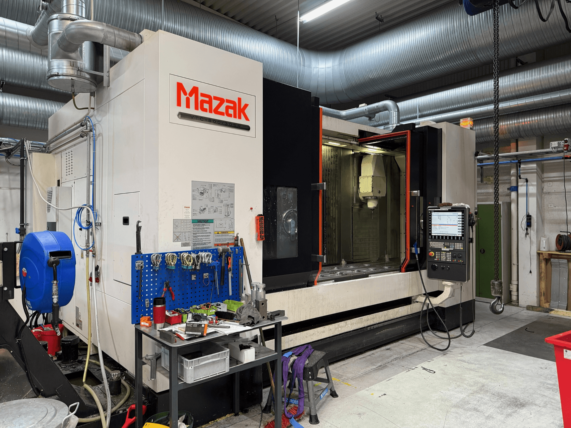 Macchina CNC Mazak vista frontalmente, con comandi, utensili e spazio di lavoro in un ambiente di lavorazione.