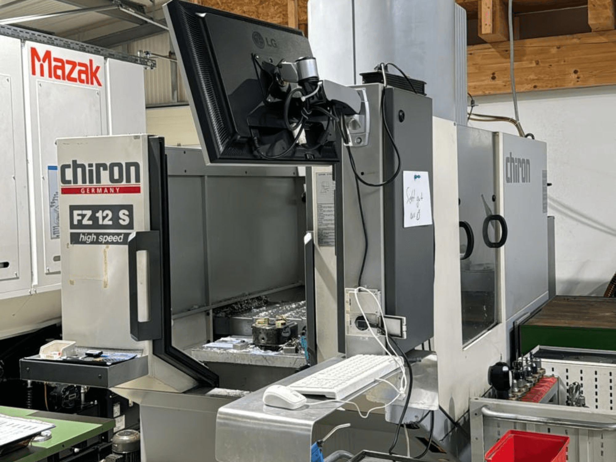 Vista verticale del centro di lavoro ad alta velocità CHIRON FZ 12 S con schermo di controllo e detriti del processo di lavorazione.