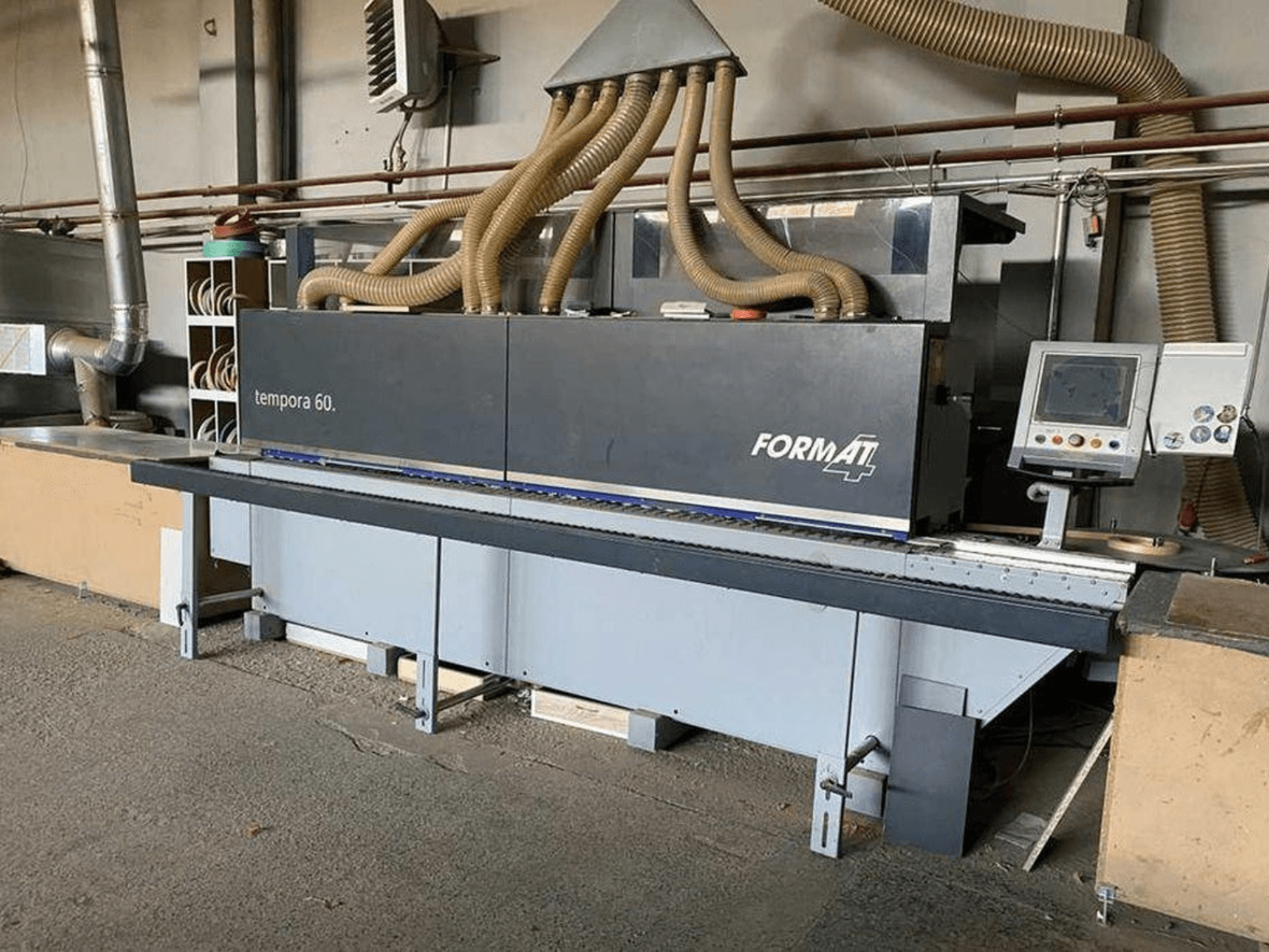 Macchina bordatrice FORMAT4 Tempora 60 in vista laterale, con tubi multipli e pannello di controllo con pulsanti e schermo.