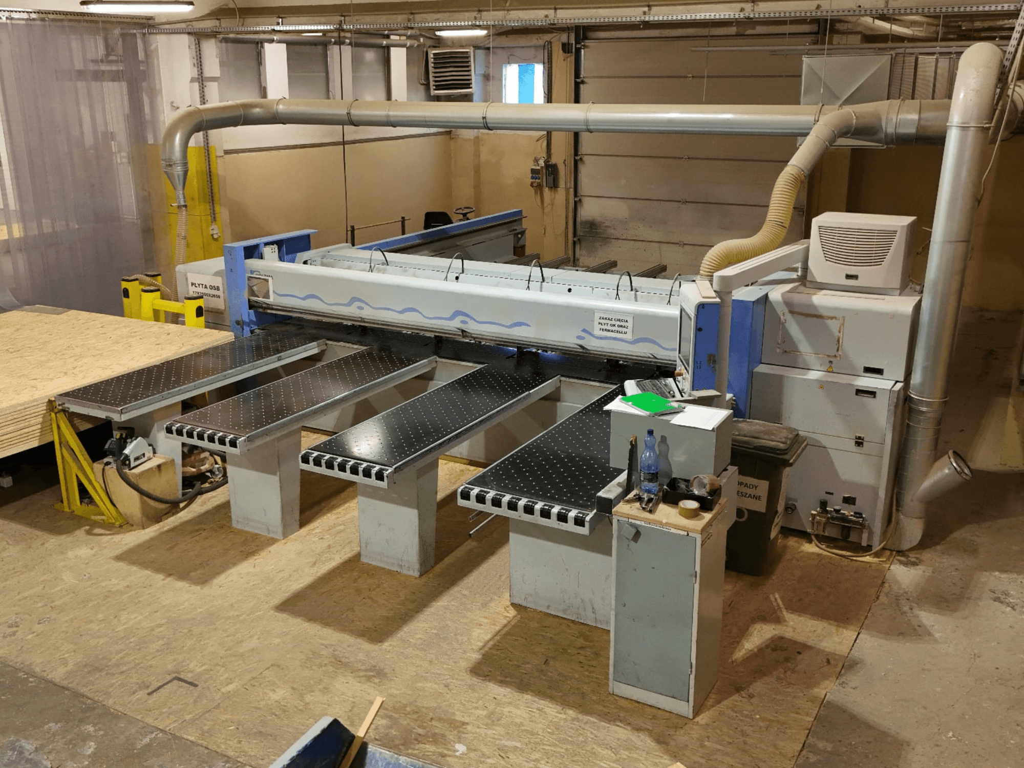 Sega a pannelli HOLZMA HPP 350/43/38 in un'officina, vista dall'alto, con l'area di taglio e i tavoli di appoggio.