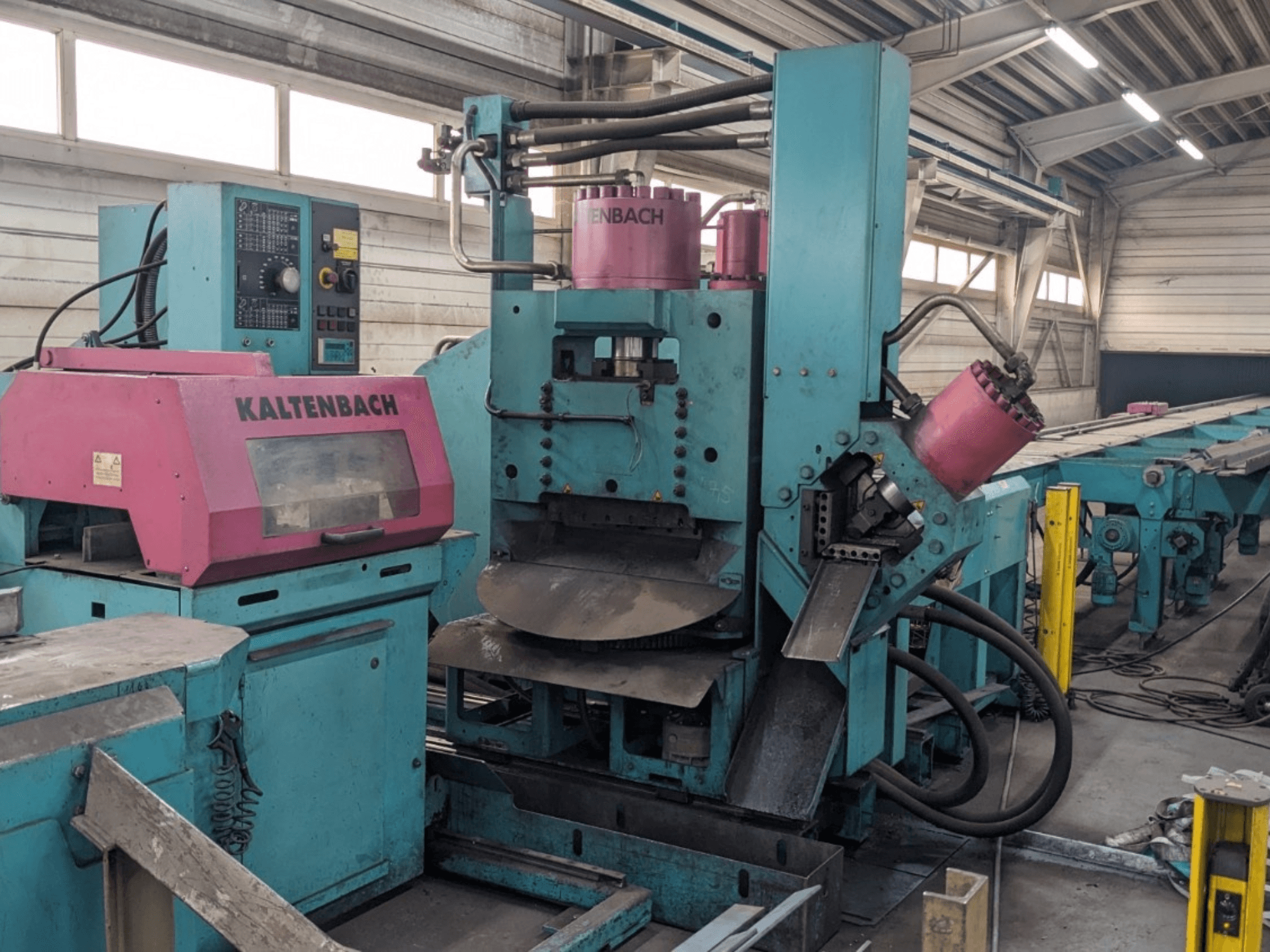 Macchina industriale KALTENBACH di colore verde e rosa, vista frontale, con pannello di controllo e componenti idraulici.