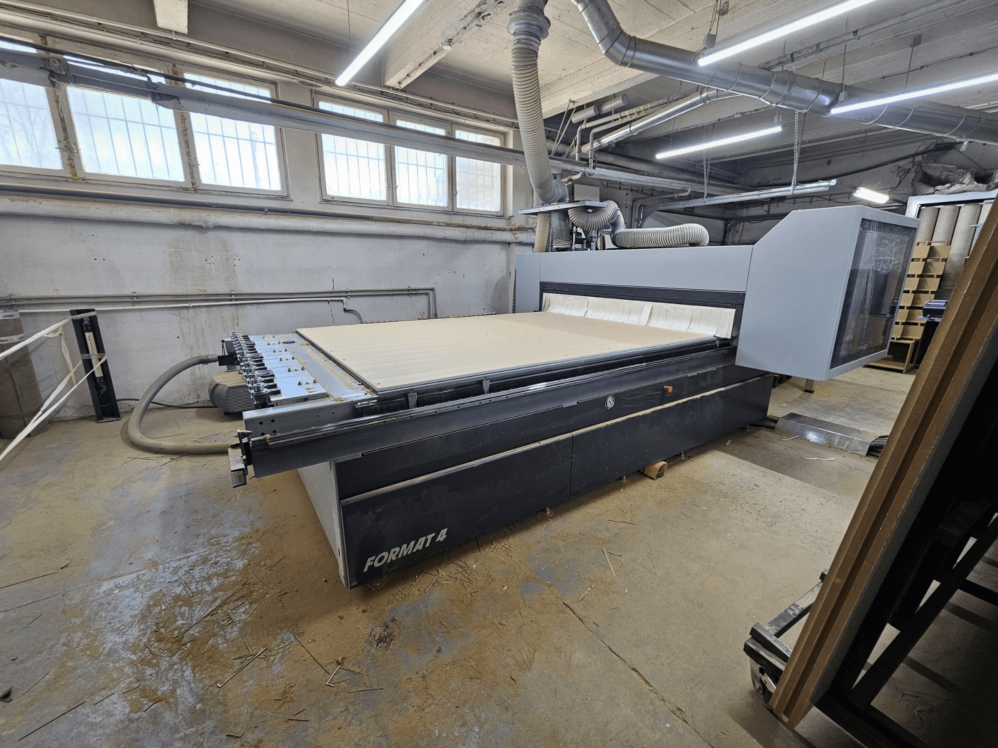 Router CNC FORMAT4 Profit H80 21.31, vista laterale che mostra l'ampio tavolo di lavoro e il pannello di controllo in un'officina.
