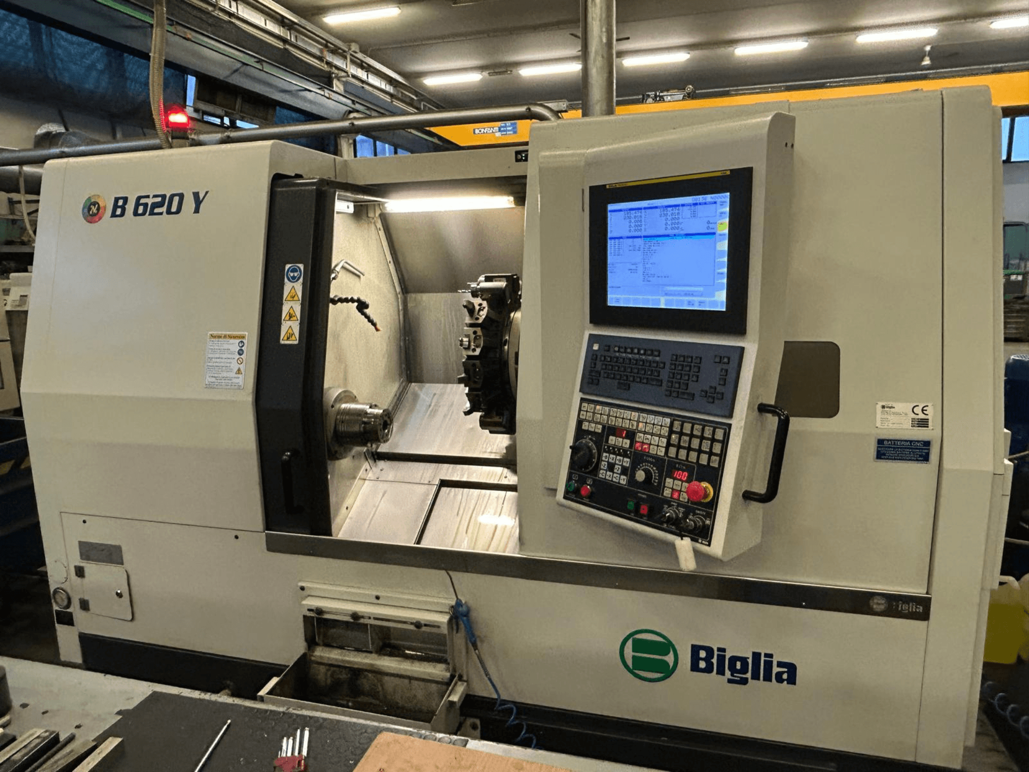 Tornio a controllo numerico Biglia B 620 Y in un'officina, vista frontale, con pannello di controllo con display digitale e componenti di lavorazione.