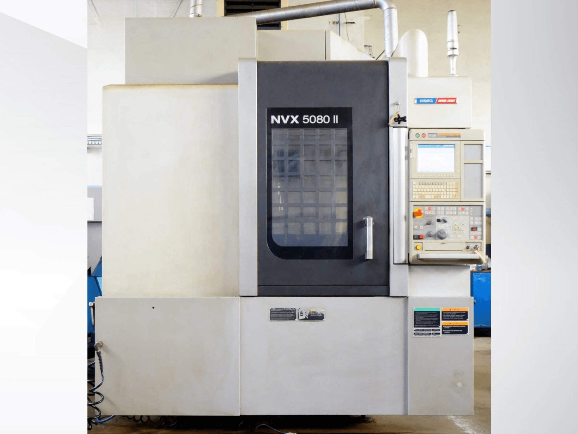 Centro di lavorazione verticale DMG Mori Seiki NVX 5080 II, vista frontale, con pannello di controllo e porta a griglia.
